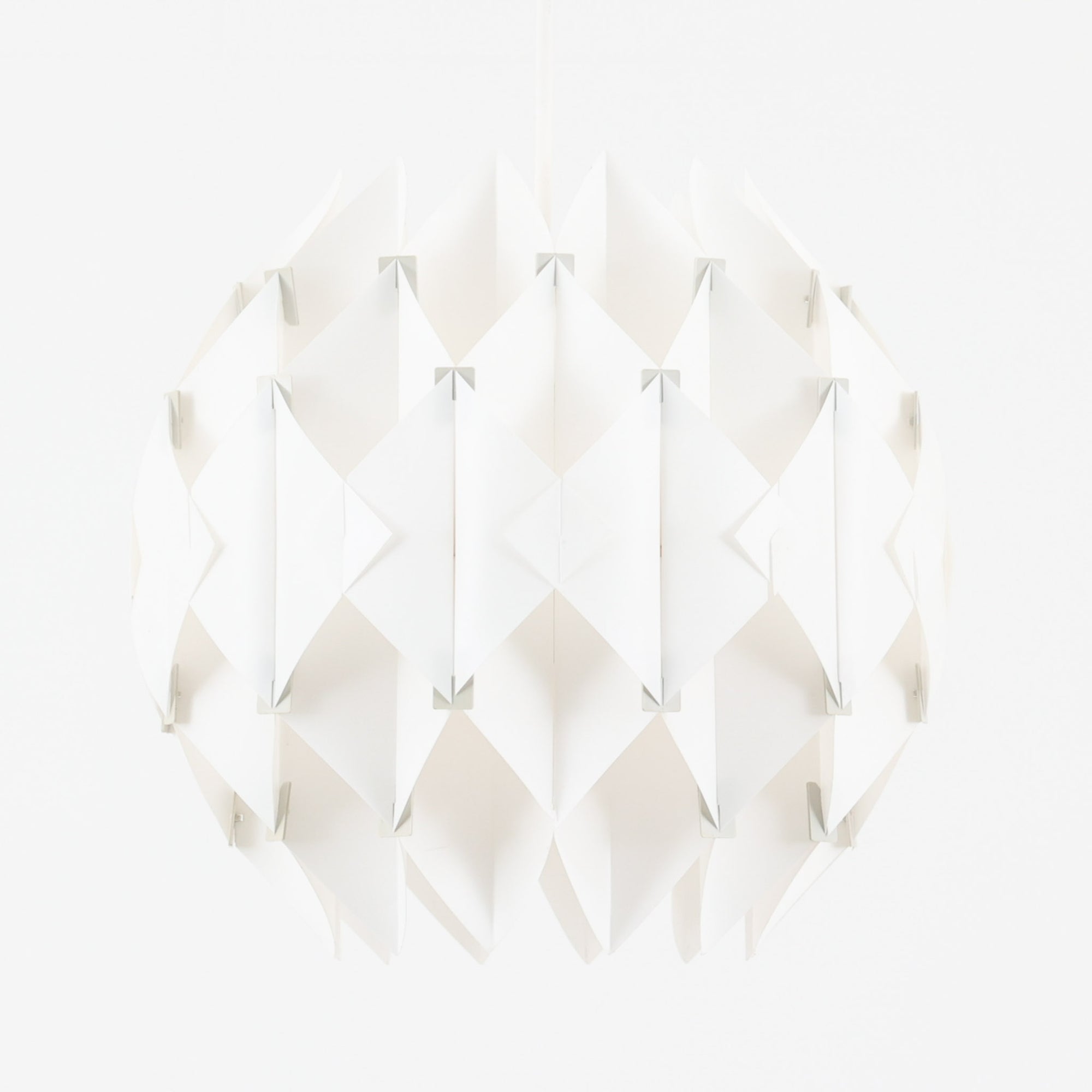 Lars Schiolerがデザインし、Hoyrupが手掛けたモデル「Butterfly」のペンダントライトです。プラスチックシートを幾何学的に組み合わせた立体構造が特徴で、点灯時には光と影が重なり合い美しい陰影を生み出します。軽やかな素材ながら彫刻的な存在感を持ち、空間のアクセントとして印象的に映える一灯。経年による風合いも相まって、北欧ビンテージならではのデザイン性と希少性を楽しめ、ダイニングやリビングに柔らかな雰囲気をもたらします。