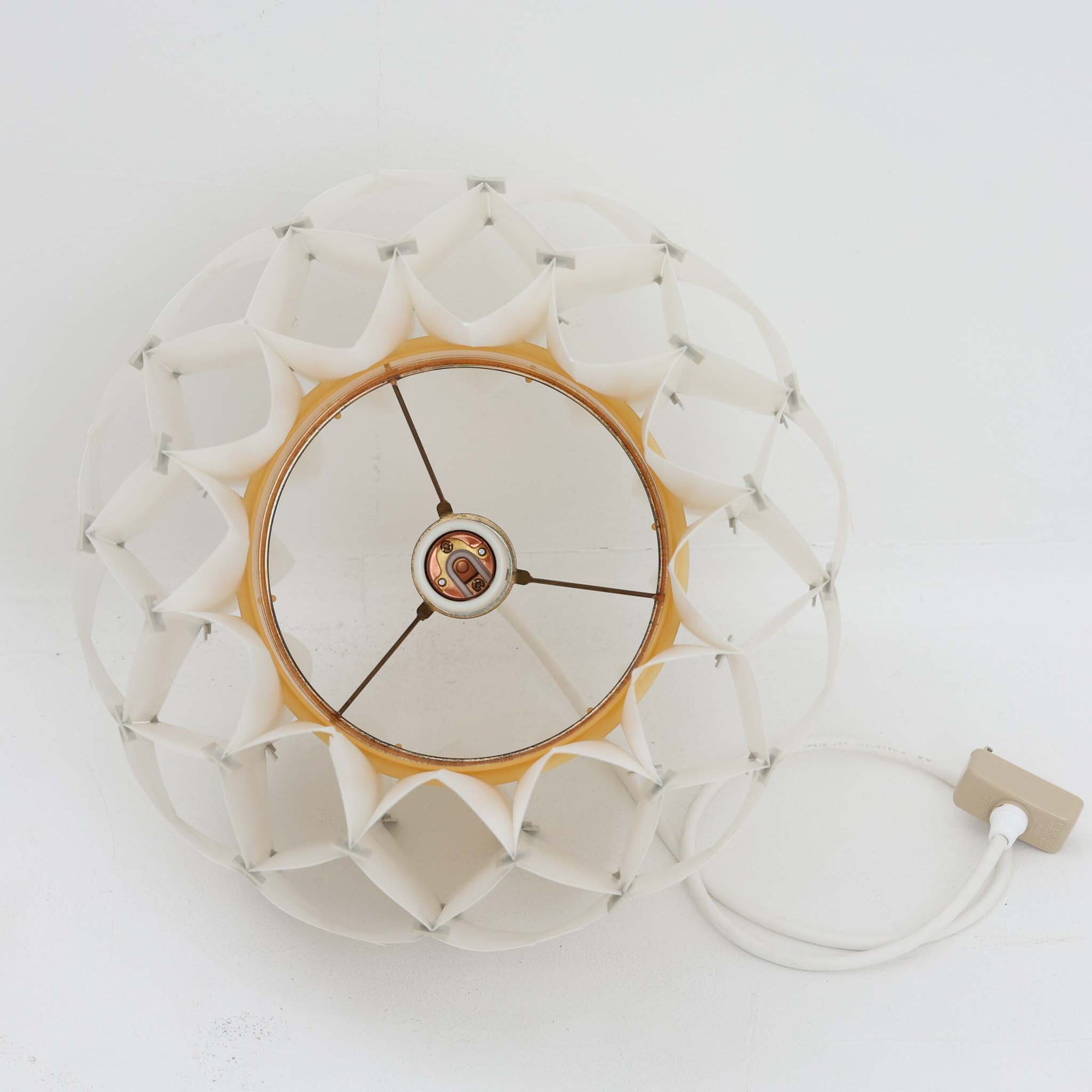 Lars Schiolerがデザインし、Hoyrupが手掛けたモデル「Butterfly」のペンダントライトです。プラスチックシートを幾何学的に組み合わせた立体構造が特徴で、点灯時には光と影が重なり合い美しい陰影を生み出します。軽やかな素材ながら彫刻的な存在感を持ち、空間のアクセントとして印象的に映える一灯。経年による風合いも相まって、北欧ビンテージならではのデザイン性と希少性を楽しめ、ダイニングやリビングに柔らかな雰囲気をもたらします。