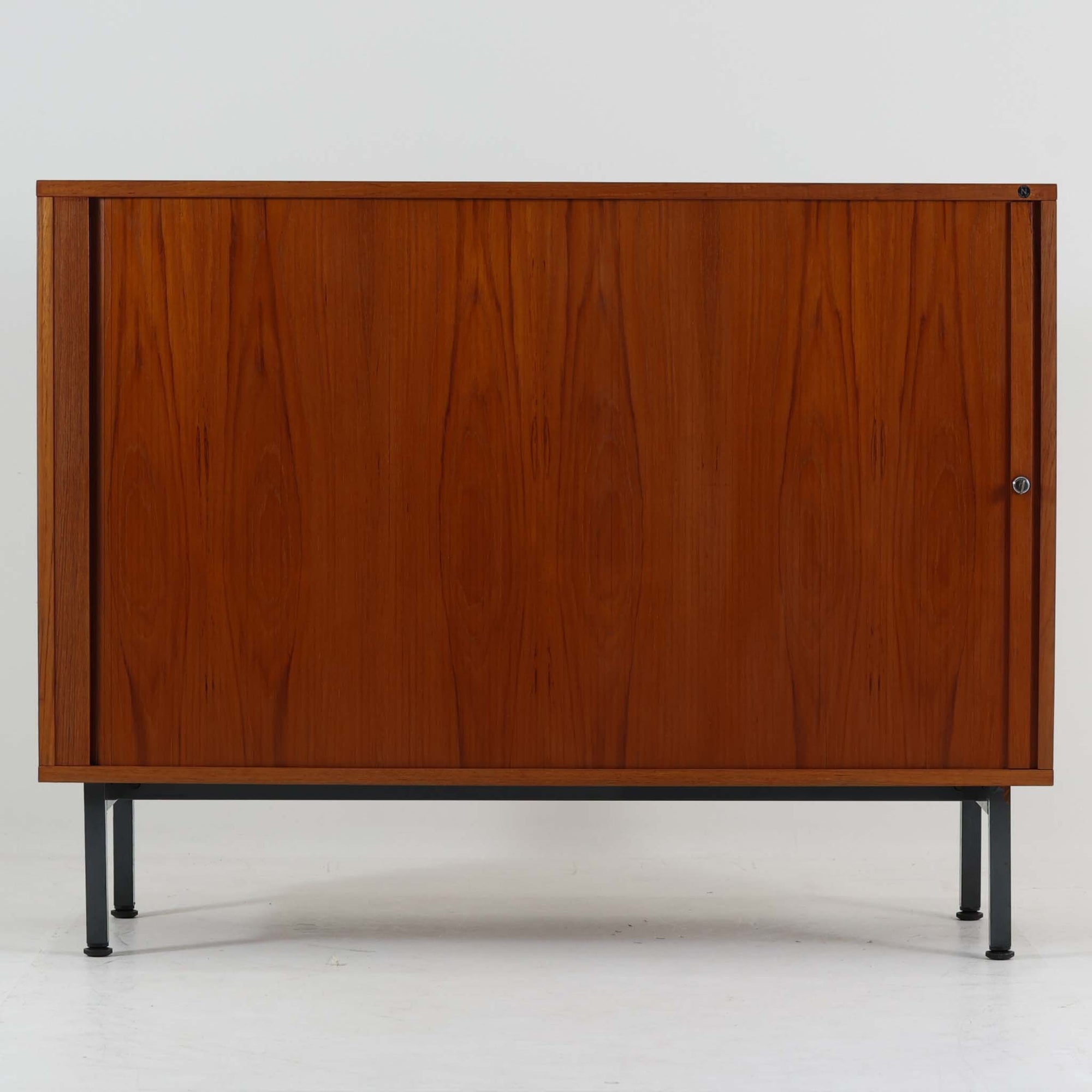 Marius Byrialsen（マリウス・ビリアルセン）デザイン、Nipu（ニプ）製のデンマーク製蛇腹キャビネットです。幅120cmの存在感あるサイズに、滑らかに開閉する蛇腹扉とシャープなスチール脚を組み合わせた、機能美あふれる一台。内部はオープンスペースと4マスの仕切り収納で構成され、レコードや書類、小物、オブジェを美しく整理できます。チーク材の流れるような木目と経年で深みを増した艶やかな木肌が、洗練された佇まいをより引き立て、リビングのサイドボードやワークスペースの収納家具としても活躍。デザイナー性の高い構造と希少な蛇腹機構が、北欧ビンテージならではの上質な存在感を空間にもたらします。