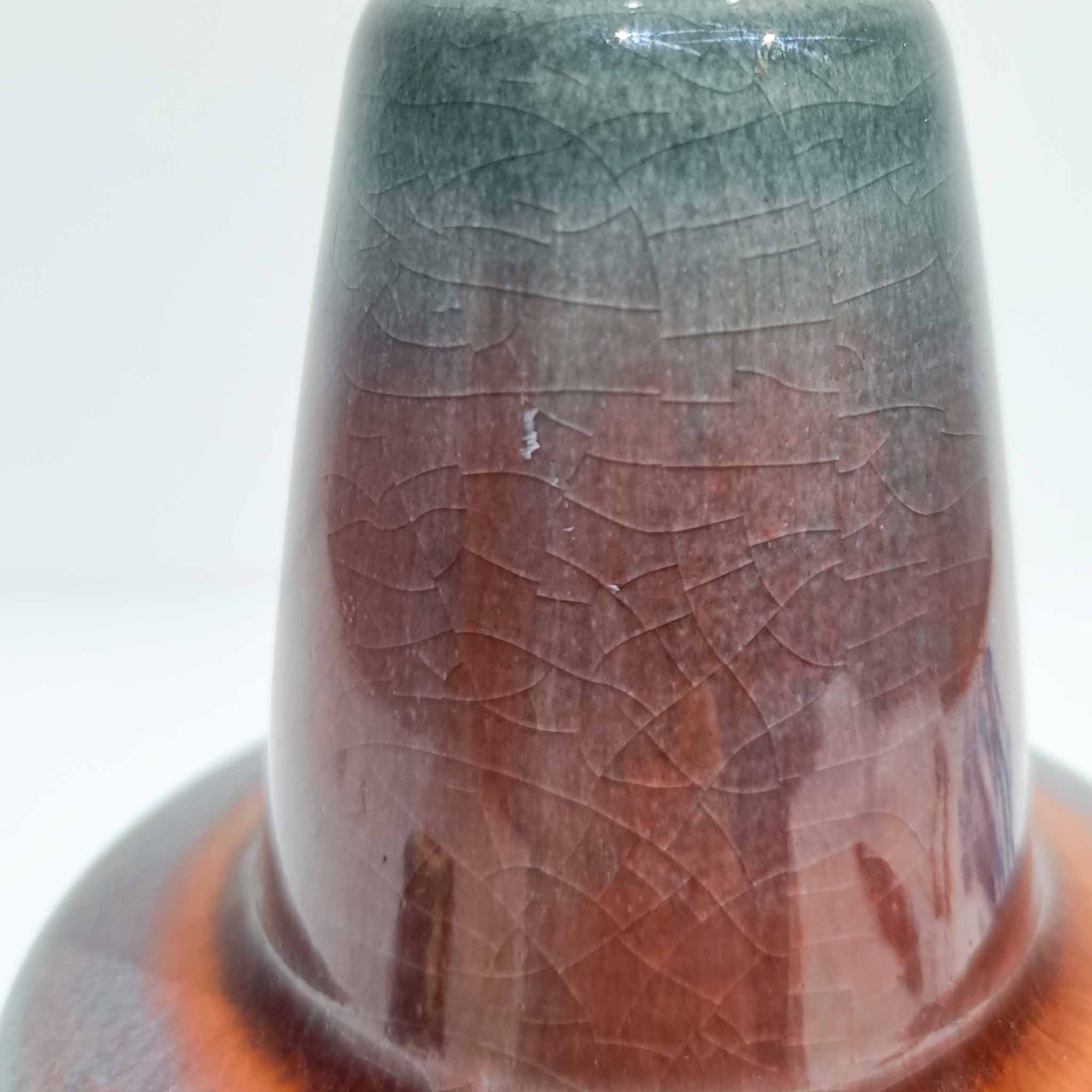 Rigmor Nielsenがデザインし、Soholm Keramikが手掛けたテーブルランプです。高さ37cmの取り入れやすいサイズに、艶やかな陶磁器ベースとナチュラルなリネンシェードを組み合わせた、落ち着きある北欧ビンテージらしい一台。ベースには規則的な立体リブ装飾が施され、陰影豊かな表情と彫刻的な存在感を生み出しています。点灯時にはシェード越しの柔らかな光が釉薬の奥行きや貫入の表情を引き立て、チェストやサイドテーブル、ベッドサイドに穏やかな雰囲気を演出。Rigmor Nielsenらしい造形美とSoholmの高い陶芸技術が感じられる、希少性の高いビンテージ照明です。