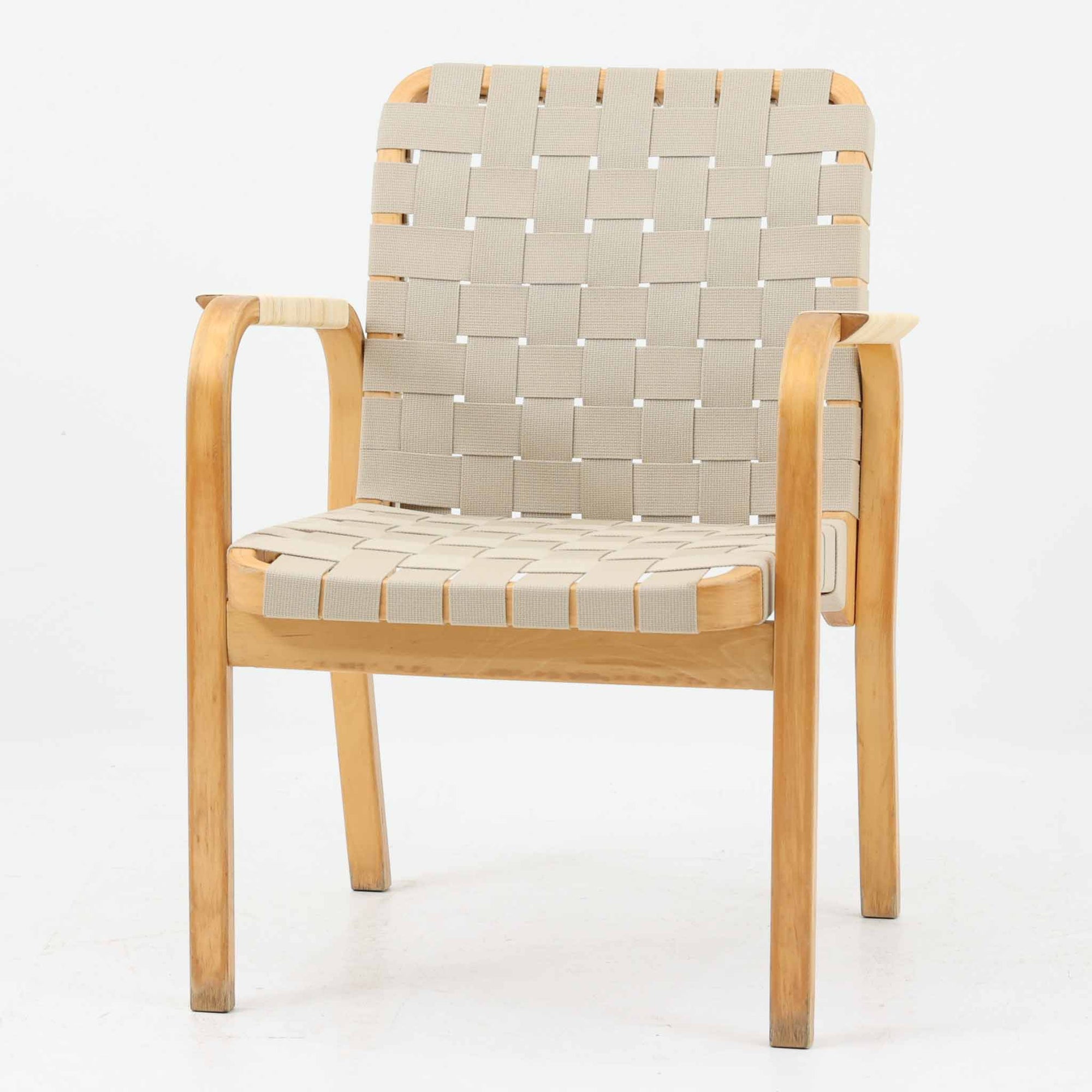 Alvar Aaltoがデザインし、Artekより製造された「ARMCHAIR 45」です。バーチ材を曲げ加工した美しいフレームと、背・座に張られたウェービングテープが生み出す軽快なデザインは、アアルトを代表する名作のひとつ。しなやかな弾力と快適な座り心地を備え、肘掛け付きのゆったりとした設計で読書やくつろぎの時間にも最適です。北欧デザインらしい機能美と、経年によって深まる素材の風合いを兼ね備えた、長く愛用できるビンテージチェアです。