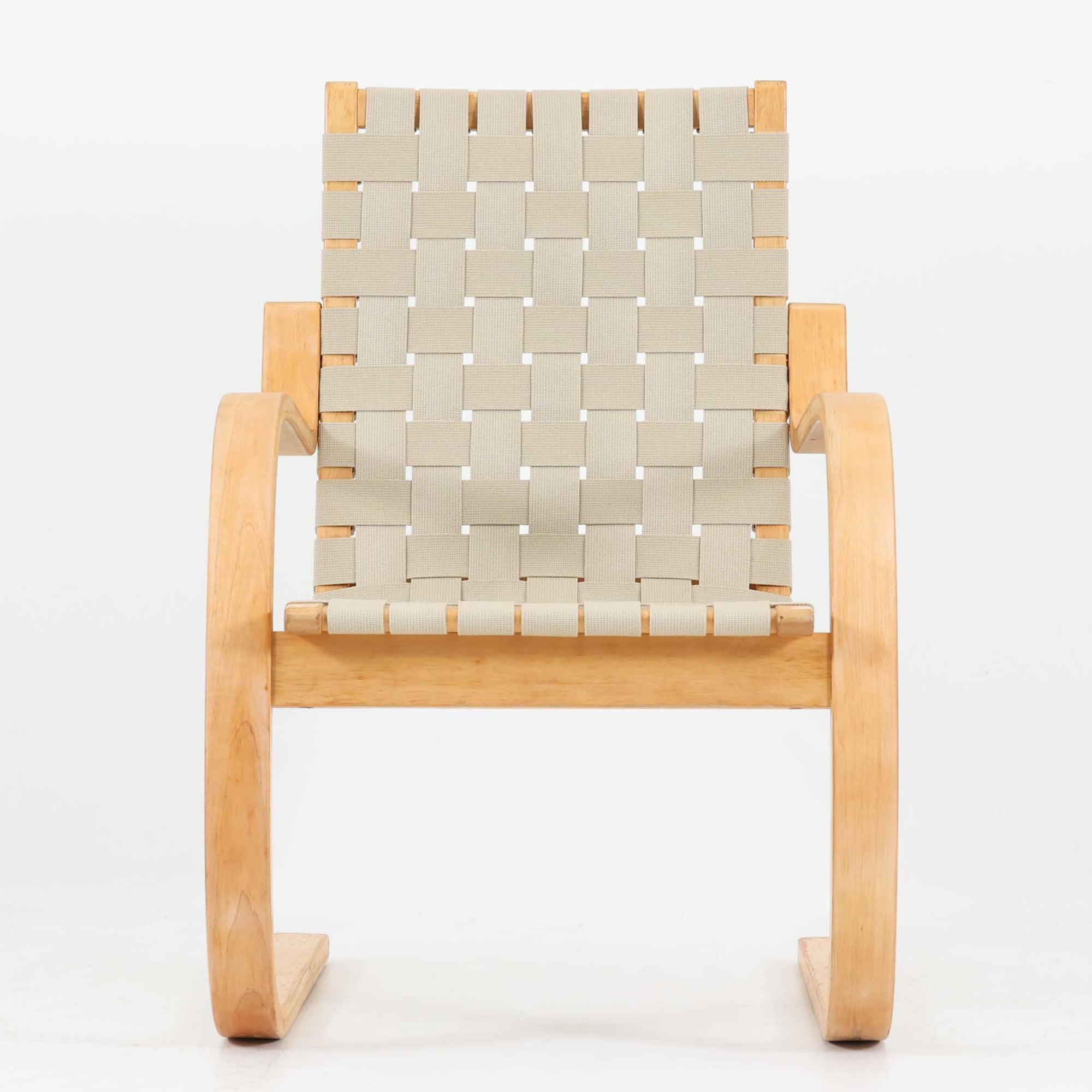 Alvar Aaltoが手掛けたARMCHAIR 406は、しなやかな曲線を描く成形バーチ材フレームが印象的な北欧モダンの名作です。アームから脚部へと流れる一体感のあるフォルムと、ウェビングテープを格子状に編み込んだ座面・背もたれが軽やかな存在感を演出します。身体を包み込むような柔軟性と快適な座り心地を備え、読書やラウンジスペースなどにも最適です。経年による風合いも魅力となり、機能性と造形美を兼ね備えた北欧ビンテージならではの価値を楽しめます。