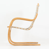 Alvar Aaltoが手掛けたARMCHAIR 406は、しなやかな曲線を描く成形バーチ材フレームが印象的な北欧モダンの名作です。アームから脚部へと流れる一体感のあるフォルムと、ウェビングテープを格子状に編み込んだ座面・背もたれが軽やかな存在感を演出します。身体を包み込むような柔軟性と快適な座り心地を備え、読書やラウンジスペースなどにも最適です。経年による風合いも魅力となり、機能性と造形美を兼ね備えた北欧ビンテージならではの価値を楽しめます。
