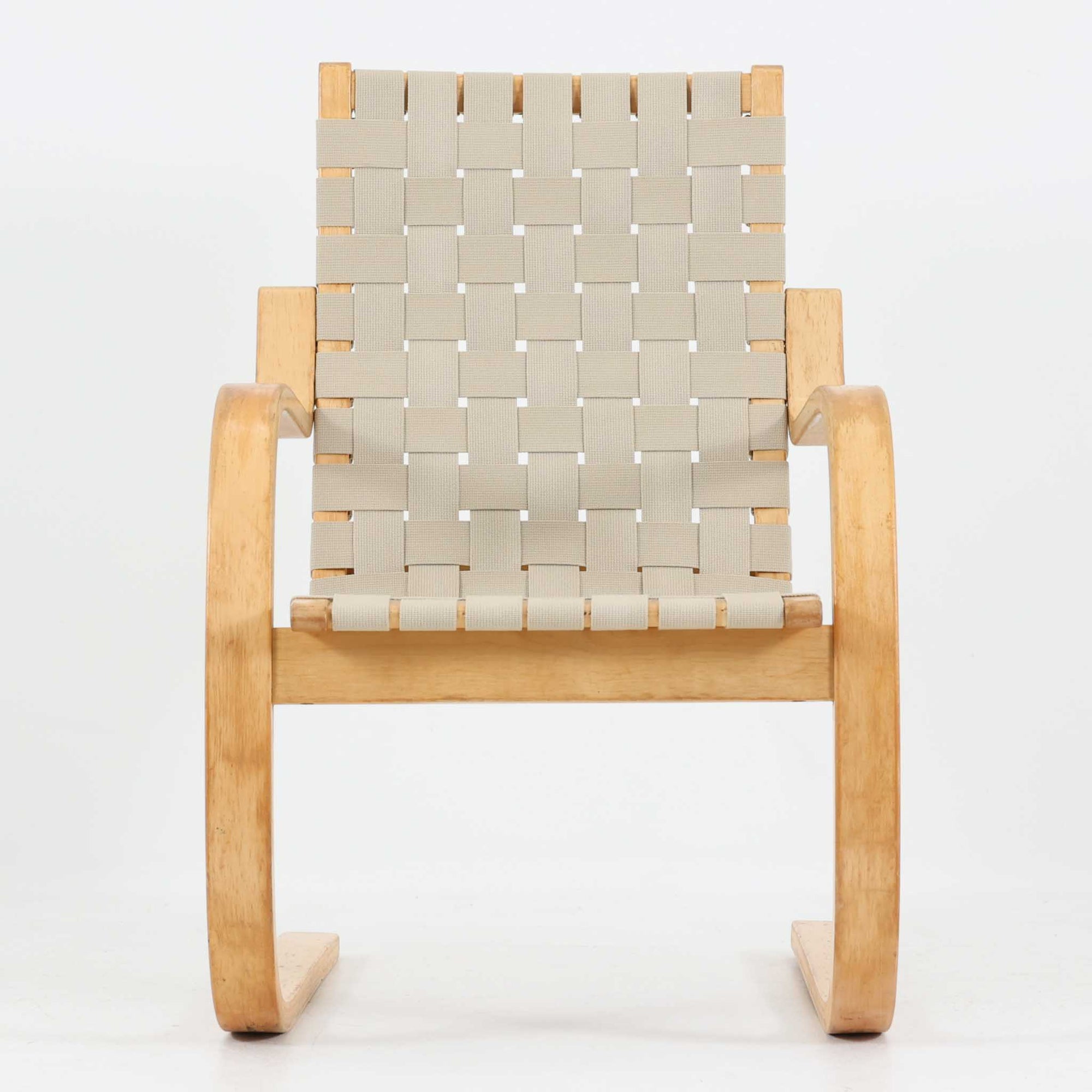 Alvar Aaltoが手掛けたARMCHAIR 406は、しなやかな曲線を描く成形バーチ材フレームが印象的な北欧モダンの名作です。アームから脚部へと流れる一体感のあるフォルムと、ウェビングテープを格子状に編み込んだ座面・背もたれが軽やかな存在感を演出します。身体を包み込むような柔軟性と快適な座り心地を備え、読書やラウンジスペースなどにも最適です。経年による風合いも魅力となり、機能性と造形美を兼ね備えた北欧ビンテージならではの価値を楽しめます。