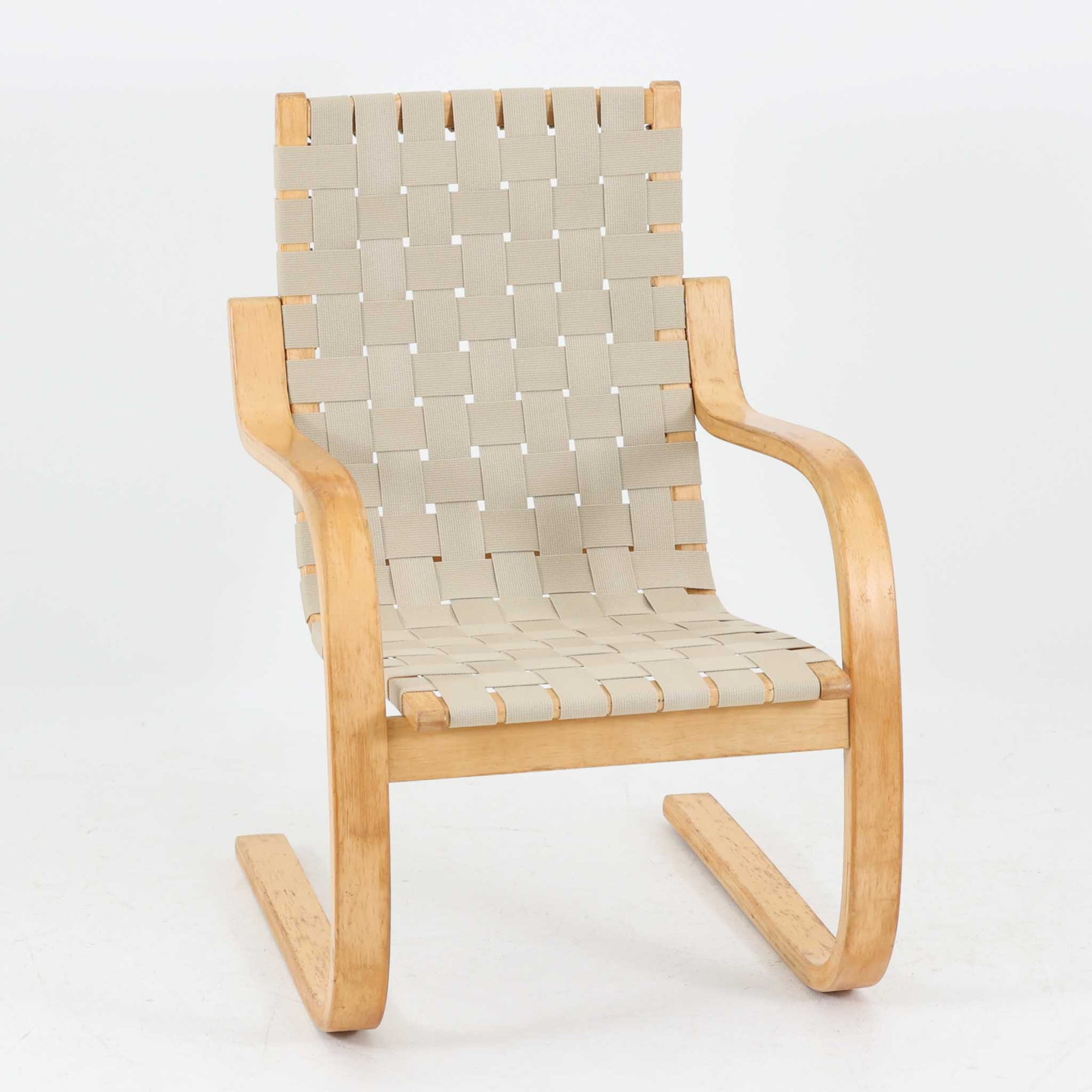 Alvar Aaltoが手掛けたARMCHAIR 406は、しなやかな曲線を描く成形バーチ材フレームが印象的な北欧モダンの名作です。アームから脚部へと流れる一体感のあるフォルムと、ウェビングテープを格子状に編み込んだ座面・背もたれが軽やかな存在感を演出します。身体を包み込むような柔軟性と快適な座り心地を備え、読書やラウンジスペースなどにも最適です。経年による風合いも魅力となり、機能性と造形美を兼ね備えた北欧ビンテージならではの価値を楽しめます。