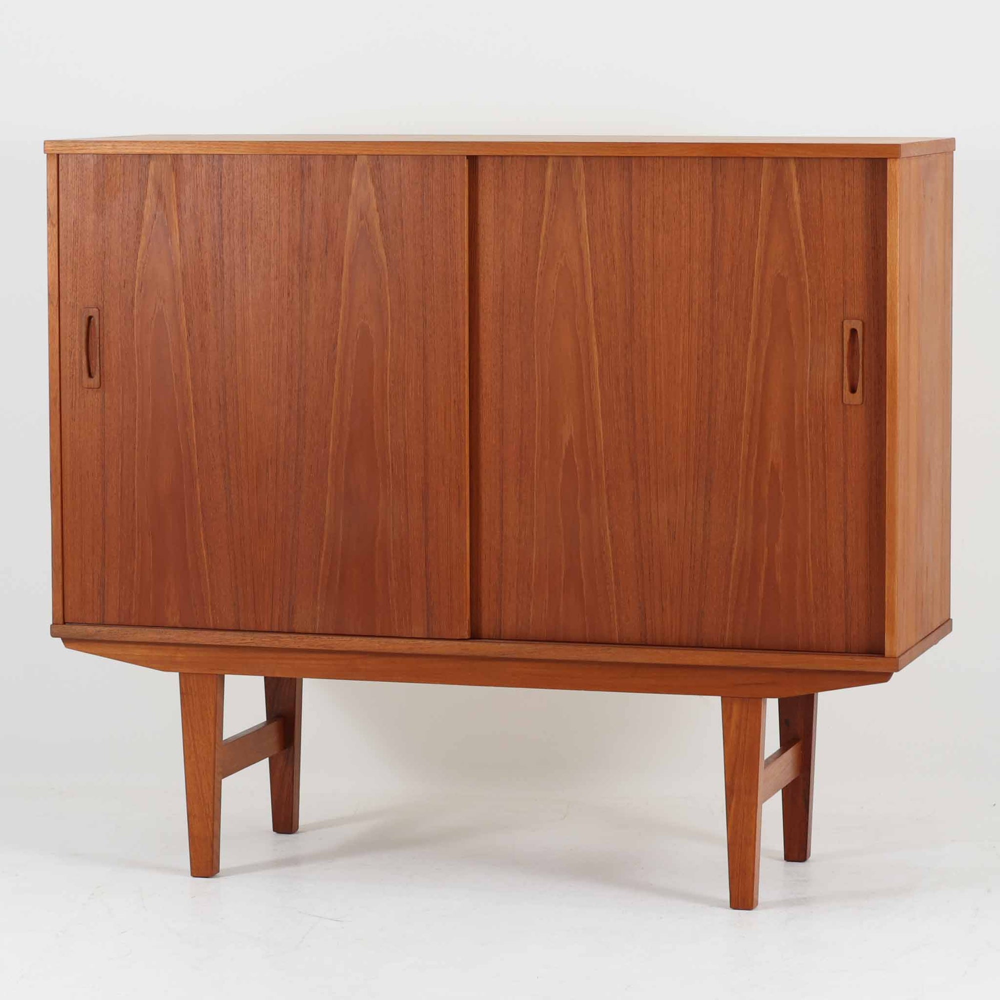 良質な木材を使用した本体は、美しい木目と経年により深みを増した色艶が魅力で、空間に落ち着いた存在感をもたらします。コンパクトなサイズ感ながら、引き戸内部には可動棚やトレイ収納を備え、食器や書類、小物を機能的に整理できる実用的な設計。すっきりとしたフォルムに対し、わずかに外側へ広がる脚部が軽やかさと安定感を両立し、ビンテージならではの丁寧な作りと佇まいを感じさせます。リビングやダイニングの収納家具としてはもちろん、ディスプレイ台としても活躍する一台です。