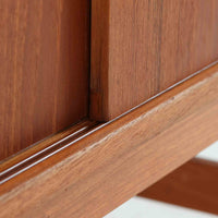 良質な木材を使用した本体は、美しい木目と経年により深みを増した色艶が魅力で、空間に落ち着いた存在感をもたらします。コンパクトなサイズ感ながら、引き戸内部には可動棚やトレイ収納を備え、食器や書類、小物を機能的に整理できる実用的な設計。すっきりとしたフォルムに対し、わずかに外側へ広がる脚部が軽やかさと安定感を両立し、ビンテージならではの丁寧な作りと佇まいを感じさせます。リビングやダイニングの収納家具としてはもちろん、ディスプレイ台としても活躍する一台です。