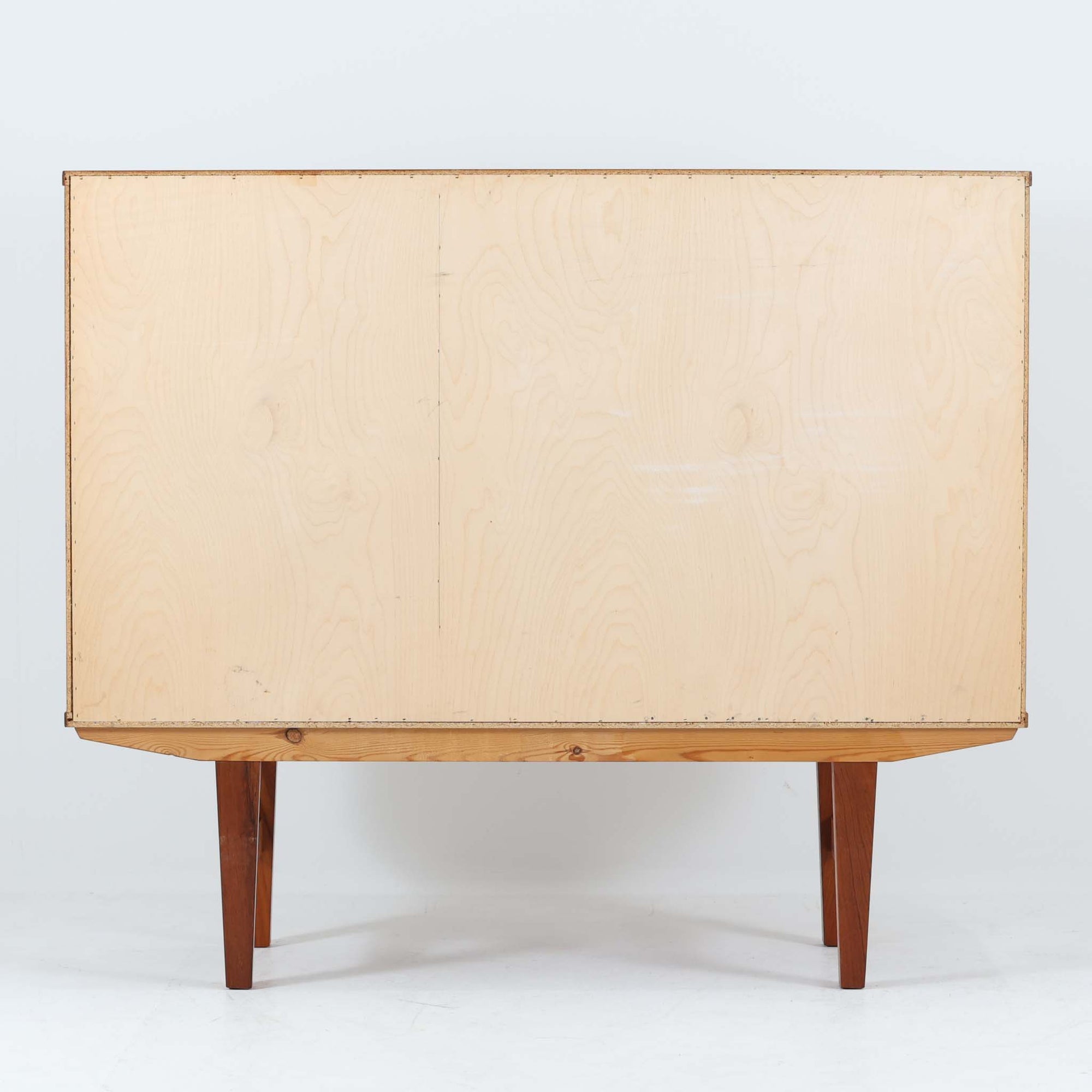 良質な木材を使用した本体は、美しい木目と経年により深みを増した色艶が魅力で、空間に落ち着いた存在感をもたらします。コンパクトなサイズ感ながら、引き戸内部には可動棚やトレイ収納を備え、食器や書類、小物を機能的に整理できる実用的な設計。すっきりとしたフォルムに対し、わずかに外側へ広がる脚部が軽やかさと安定感を両立し、ビンテージならではの丁寧な作りと佇まいを感じさせます。リビングやダイニングの収納家具としてはもちろん、ディスプレイ台としても活躍する一台です。