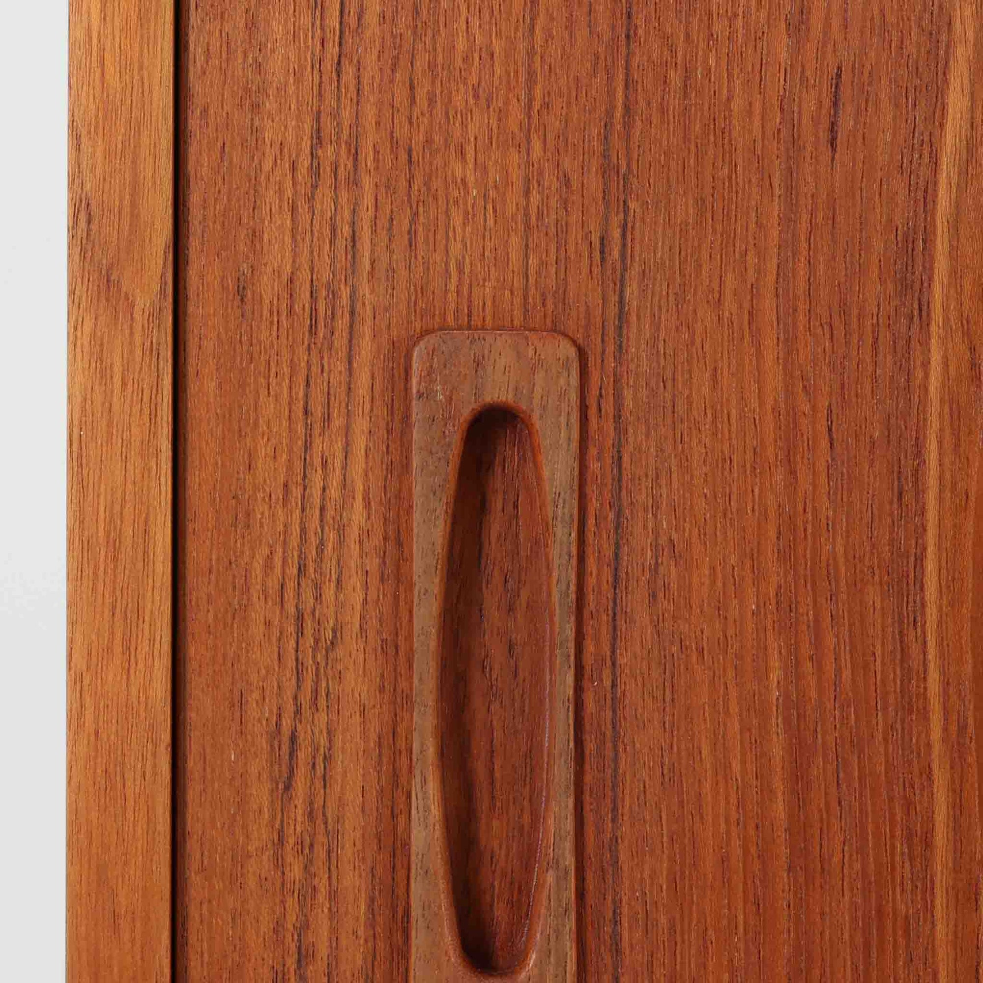 良質な木材を使用した本体は、美しい木目と経年により深みを増した色艶が魅力で、空間に落ち着いた存在感をもたらします。コンパクトなサイズ感ながら、引き戸内部には可動棚やトレイ収納を備え、食器や書類、小物を機能的に整理できる実用的な設計。すっきりとしたフォルムに対し、わずかに外側へ広がる脚部が軽やかさと安定感を両立し、ビンテージならではの丁寧な作りと佇まいを感じさせます。リビングやダイニングの収納家具としてはもちろん、ディスプレイ台としても活躍する一台です。