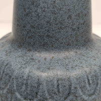 Einar Johansenがデザインし、Soholm Keramikが製作したモデル1015のテーブルランプです。高さ39cmの程よい存在感に、青みを帯びたグレートーンの陶磁器ベースとやわらかなリネンシェードを組み合わせた、洗練された北欧ビンテージらしい一台。ベース下部には連続する半円状のレリーフが丁寧に施され、穏やかな陰影と柔らかなリズム感を生み出しています。点灯時にはシェード越しの優しい光がマットな釉薬の質感を引き立て、リビングやベッドサイド、チェスト上に落ち着いた温もりを添えます。Johansenらしい端正な造形とSoholmの高い陶芸技術が感じられる、希少性の高いビンテージ照明です。