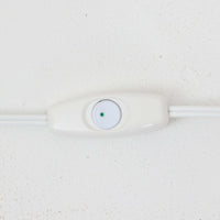 Rigmor Nielsenがデザインし、Soholm Keramikが手掛けたテーブルランプです。高さ37cmの取り入れやすいサイズに、艶やかな陶磁器ベースとナチュラルなリネンシェードを組み合わせた、落ち着きある北欧ビンテージらしい一台。ベースには規則的な立体リブ装飾が施され、陰影豊かな表情と彫刻的な存在感を生み出しています。点灯時にはシェード越しの柔らかな光が釉薬の奥行きや貫入の表情を引き立て、チェストやサイドテーブル、ベッドサイドに穏やかな雰囲気を演出。Rigmor Nielsenらしい造形美とSoholmの高い陶芸技術が感じられる、希少性の高いビンテージ照明です。