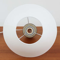 Joseph Simonデザイン、Soholm Keramik製モデル3059のデンマーク製テーブルランプです。陶磁器ベースは、やわらかなアイボリーを基調にブラウンが層状に溶け合う美しい流釉が印象的で、くびれを効かせた縦長フォルムに段差を設けた造形がミッドセンチュリーらしい端正さを感じさせます。釉薬の自然な濃淡と細かな鉄点が一点ごとに異なる豊かな表情を生み、灯りを点すとリネンシェード越しの柔らかな光が陶肌の温もりをより引き立てます。サイドテーブルやチェスト、ベッドサイドの間接照明として使いやすい高さ44cmで、北欧ビンテージならではの職人技と経年の味わいを楽しめるコレクタブルな一台です。