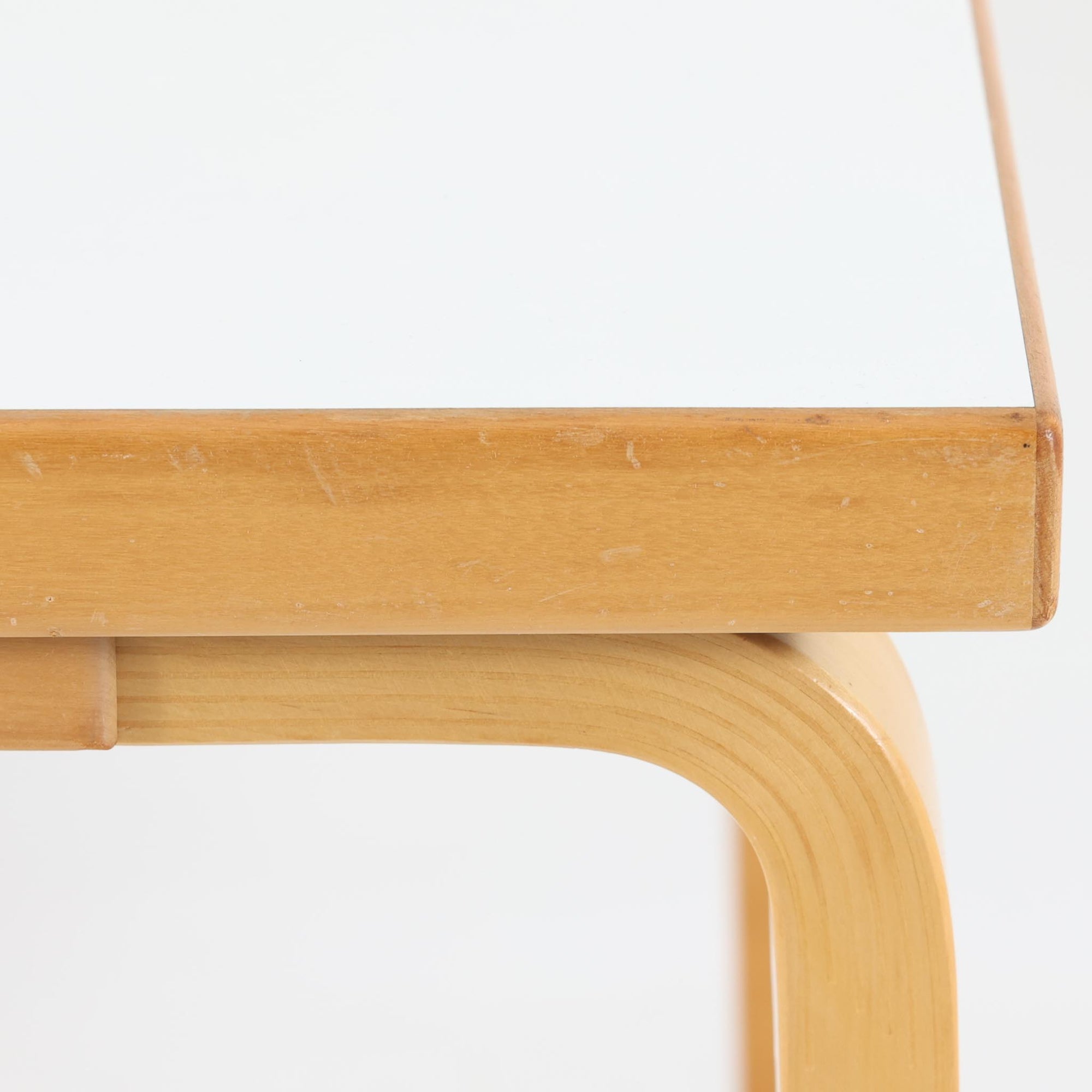 Alvar Aaltoがデザインし、Artekが製作したモデル81Cの正方形ダイニングテーブルです。バーチ材のしなやかな曲木脚とホワイトラミネート天板の組み合わせが、アアルトらしい機能美と軽やかな佇まいを生み出しています。幅75cmの扱いやすいサイズは2人用のダイニングテーブルとしてはもちろん、ワークデスクやショップ什器としても取り入れやすい一台。経年により深みを増した木肌と、長年使い込まれた天板の風合いがビンテージならではの味わいを感じさせ、Artekの普遍的なデザイン性と希少な北欧オリジナルの存在感を空間に添えてくれます。