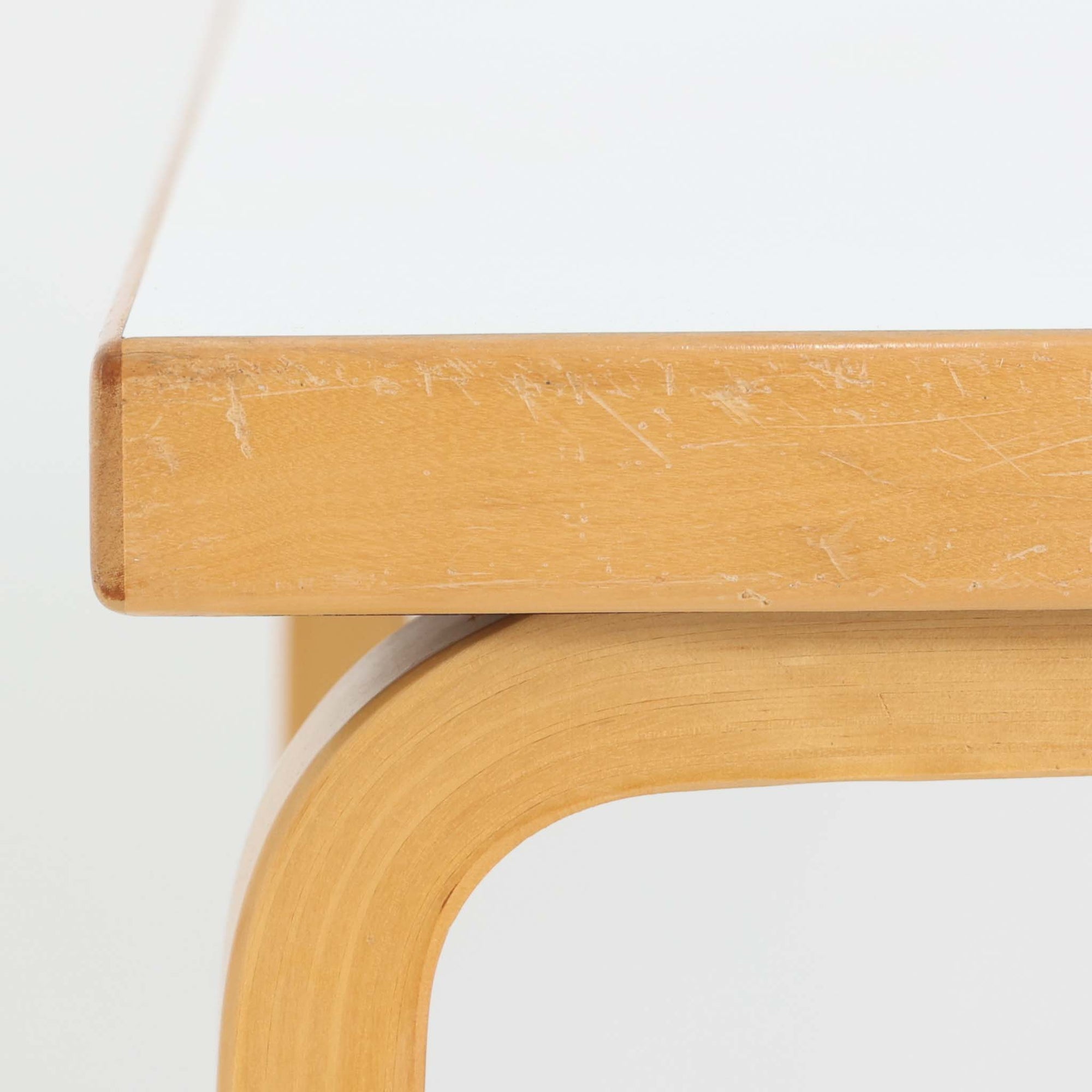 Alvar Aaltoがデザインし、Artekが製作したモデル81Cの正方形ダイニングテーブルです。バーチ材のしなやかな曲木脚とホワイトラミネート天板の組み合わせが、アアルトらしい機能美と軽やかな佇まいを生み出しています。幅75cmの扱いやすいサイズは2人用のダイニングテーブルとしてはもちろん、ワークデスクやショップ什器としても取り入れやすい一台。経年により深みを増した木肌と、長年使い込まれた天板の風合いがビンテージならではの味わいを感じさせ、Artekの普遍的なデザイン性と希少な北欧オリジナルの存在感を空間に添えてくれます。