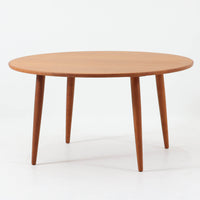 デンマーク製の円形センターテーブルです。チーク材を使用した天板は滑らかな木目と温かみのある色合いが魅力で、シンプルながら上質な存在感を放ちます。すっきりとしたラウンドフォルムと外側へ広がるテーパー脚の構造により、軽やかで安定感のある佇まいを実現。直径98cmの程よいサイズはリビングの中心に置いてくつろぎの空間を演出するほか、来客時のローテーブルとしても活躍します。経年変化による深みのある風合いが北欧ビンテージならではの魅力を引き立てる一台です。