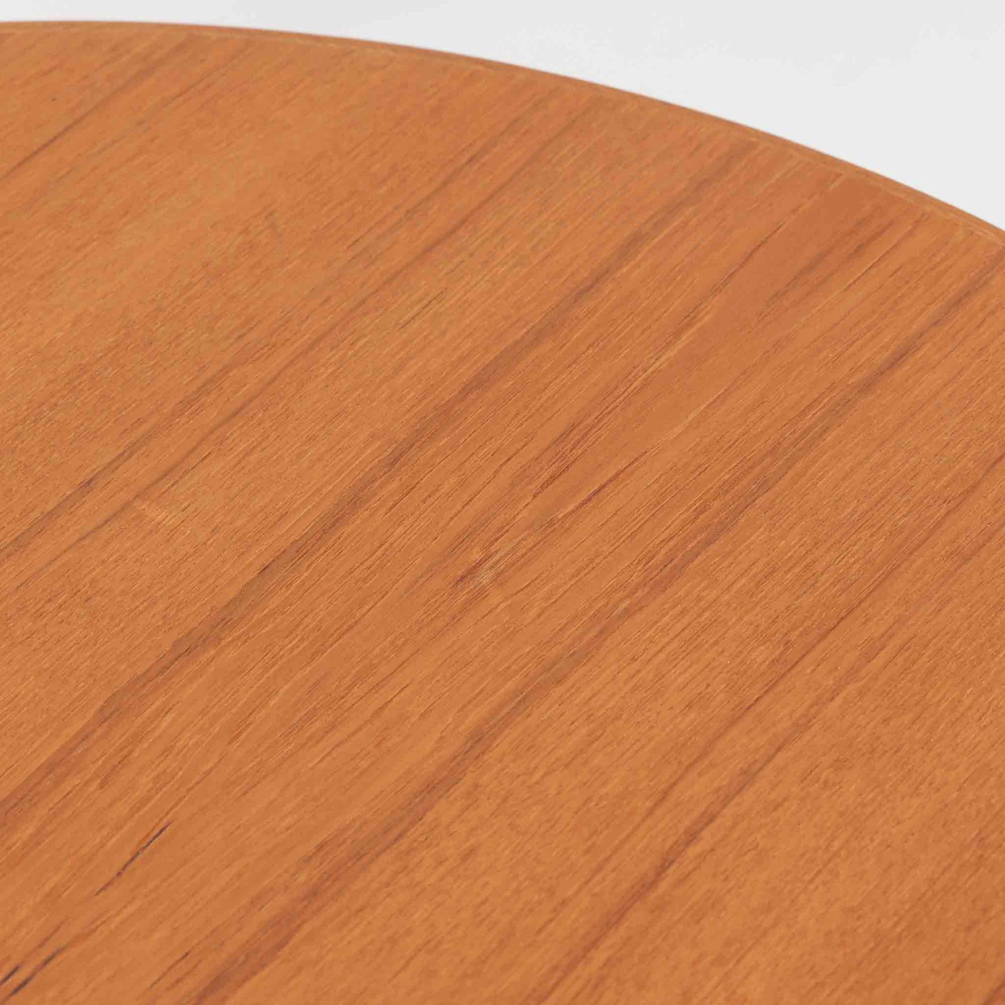 デンマーク製の円形センターテーブルです。チーク材を使用した天板は滑らかな木目と温かみのある色合いが魅力で、シンプルながら上質な存在感を放ちます。すっきりとしたラウンドフォルムと外側へ広がるテーパー脚の構造により、軽やかで安定感のある佇まいを実現。直径98cmの程よいサイズはリビングの中心に置いてくつろぎの空間を演出するほか、来客時のローテーブルとしても活躍します。経年変化による深みのある風合いが北欧ビンテージならではの魅力を引き立てる一台です。