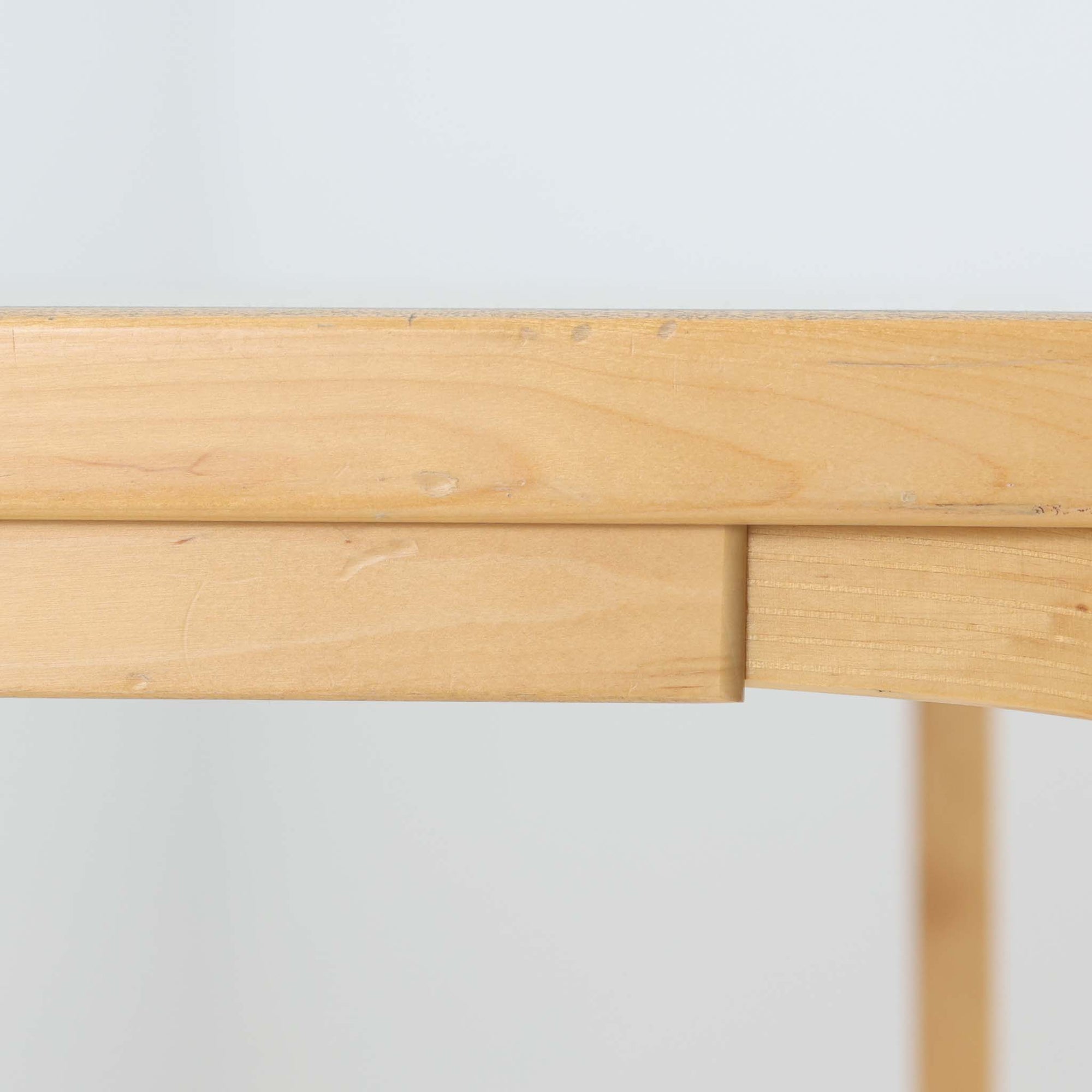 Alvar Aaltoがデザインし、Artekが製作したモデル81Aのダイニングテーブルです。バーチ材の柔らかな木肌とアアルトを象徴するLレッグの曲木構造に、落ち着いたリノリウム天板を組み合わせた、機能美あふれる北欧デザインの名作。幅150cmのゆとりあるサイズは4～6人でのダイニング使用に適しており、ワークスペースやミーティングテーブルとしても活躍します。経年により深みを増した木部の艶やかな風合いと、使い込まれた天板の味わいがビンテージならではの魅力を高め、Artekオリジナルならではの普遍的なデザイン性と希少性が空間に上質な存在感をもたらします。