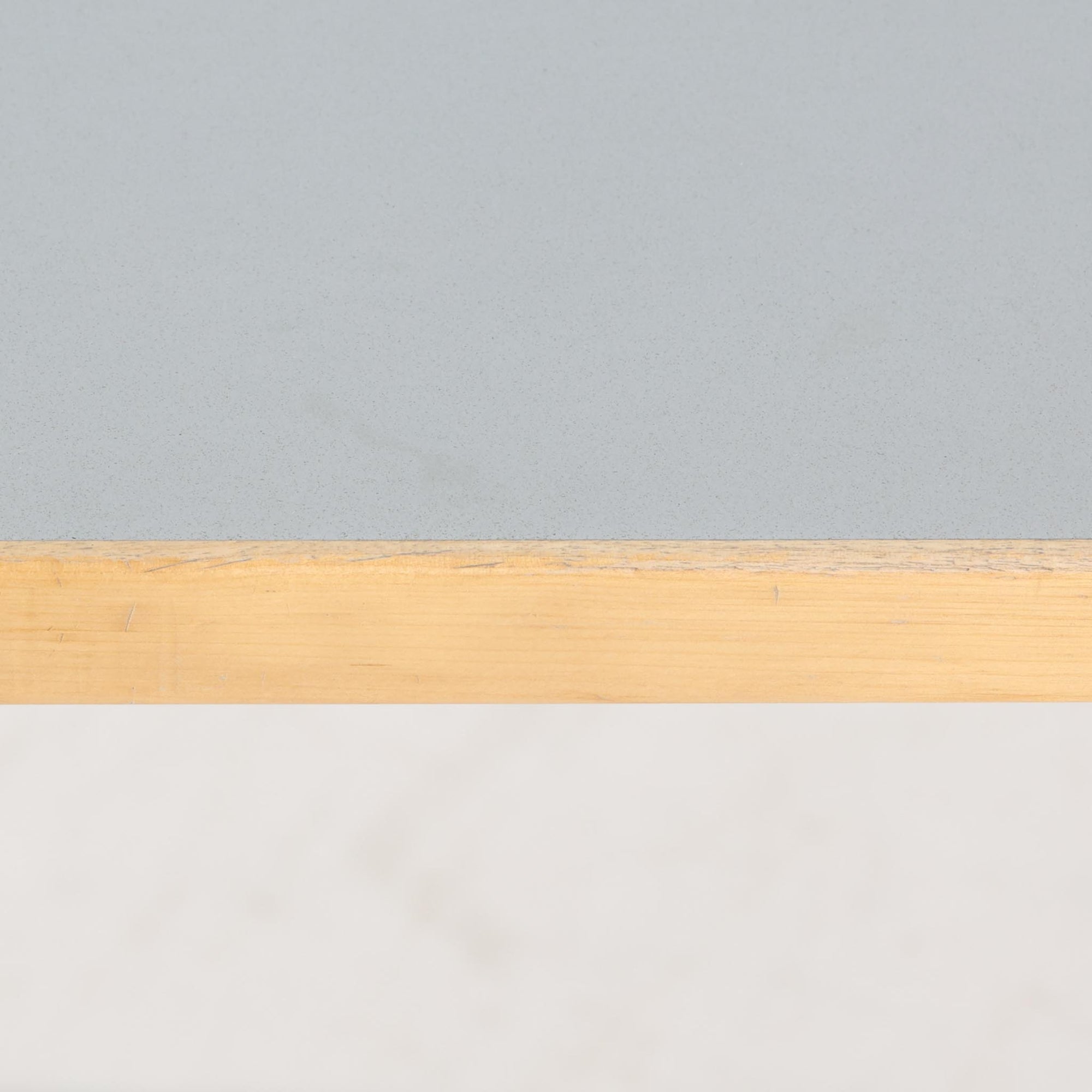 Alvar Aaltoがデザインし、Artek社より製造されたこちらのダイニングテーブルは、落ち着いたグレートーンのリノリウム天板と、美しい木肌を活かしたバーチ材の脚部を組み合わせた、北欧モダンを代表する名作です。L字型に曲げられた脚部は、アアルトらしい柔らかな造形美と高い機能性を兼ね備え、空間に軽やかな印象をもたらします。幅120cmの使い勝手のよいサイズで、ダイニングはもちろんワークスペースにも自然に馴染みます。なお、天板裏面には脚の付け替え跡が確認できたため、安心してお使いいただけるよう現状でしっかり固定しており、脚部の取り外しはできない仕様となっております。