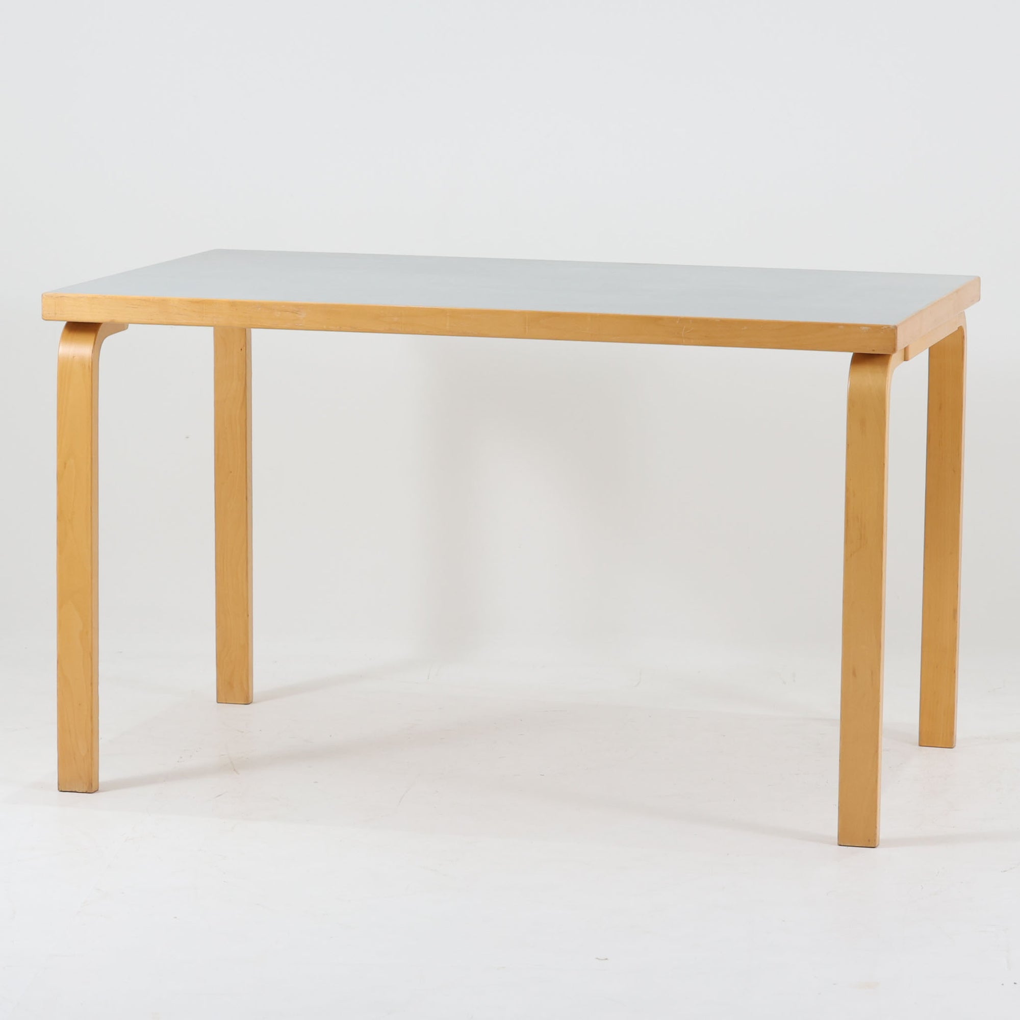 Alvar Aaltoがデザインし、Artekが製作したモデル81Bのダイニングテーブルです。バーチ材の柔らかな木肌と、アアルトを象徴するLレッグの曲木構造にリノリウム天板を組み合わせた、北欧モダンを代表するタイムレスな一台。幅120cmの使いやすいサイズは4人掛けのダイニングテーブルとしてはもちろん、書斎やワークスペースのデスクとしても取り入れやすい設計です。経年によって深みを増した木部の艶やかな表情と、使い込まれた天板の落ち着いた風合いがビンテージならではの魅力を高め、Artekオリジナルの希少性と普遍的なデザイン美が空間に上質な存在感をもたらします。