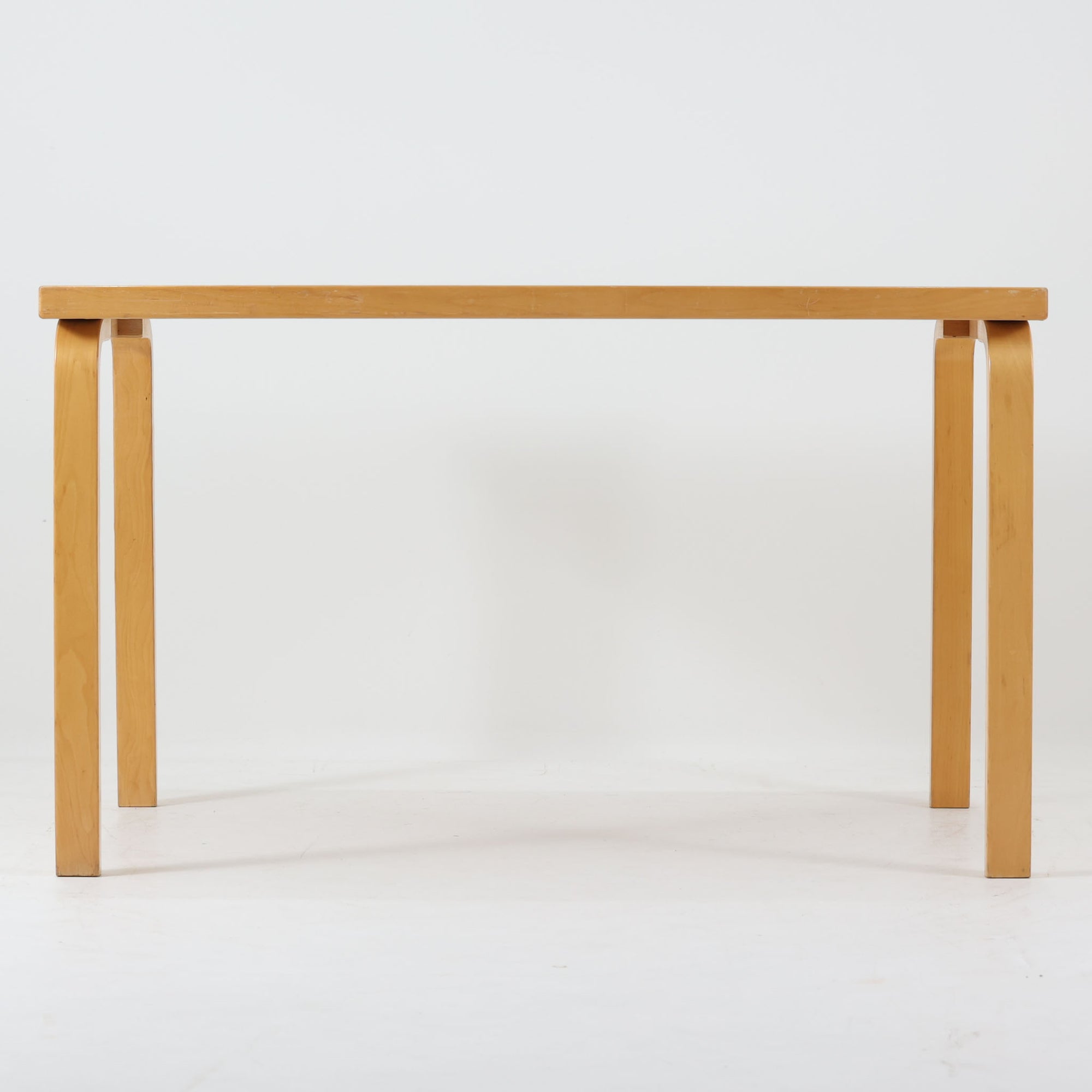 Alvar Aaltoがデザインし、Artekが製作したモデル81Bのダイニングテーブルです。バーチ材の柔らかな木肌と、アアルトを象徴するLレッグの曲木構造にリノリウム天板を組み合わせた、北欧モダンを代表するタイムレスな一台。幅120cmの使いやすいサイズは4人掛けのダイニングテーブルとしてはもちろん、書斎やワークスペースのデスクとしても取り入れやすい設計です。経年によって深みを増した木部の艶やかな表情と、使い込まれた天板の落ち着いた風合いがビンテージならではの魅力を高め、Artekオリジナルの希少性と普遍的なデザイン美が空間に上質な存在感をもたらします。