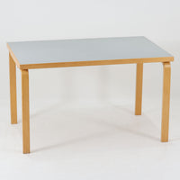 Alvar Aaltoがデザインし、Artekが製作したモデル81Bのダイニングテーブルです。バーチ材の柔らかな木肌と、アアルトを象徴するLレッグの曲木構造にリノリウム天板を組み合わせた、北欧モダンを代表するタイムレスな一台。幅120cmの使いやすいサイズは4人掛けのダイニングテーブルとしてはもちろん、書斎やワークスペースのデスクとしても取り入れやすい設計です。経年によって深みを増した木部の艶やかな表情と、使い込まれた天板の落ち着いた風合いがビンテージならではの魅力を高め、Artekオリジナルの希少性と普遍的なデザイン美が空間に上質な存在感をもたらします。