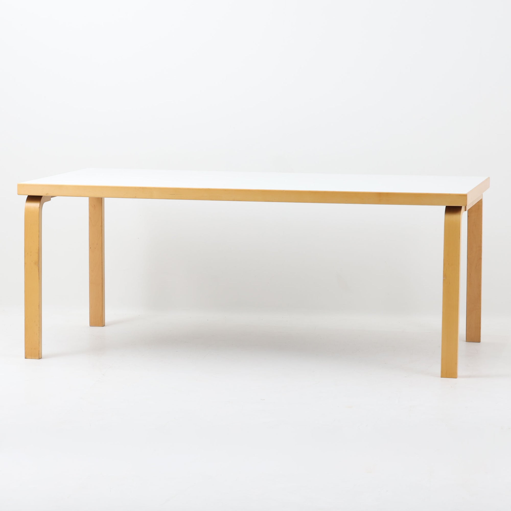 Alvar Aaltoが手掛け、Artekより製造された北欧デザインを代表するダイニングテーブルです。天板には実用性に優れたリノリウム、フレームにはバーチ材を使用し、アアルトならではの美しいLレッグ構造が軽やかな印象を与えます。無駄を削ぎ落としたシンプルなフォルムは空間に自然に溶け込み、幅182cmのゆとりあるサイズでダイニングやワークスペースにも最適です。機能美と耐久性を兼ね備えた名作として長く愛され続けており、経年による風合いも楽しめる北欧ビンテージならではの魅力を備えています。