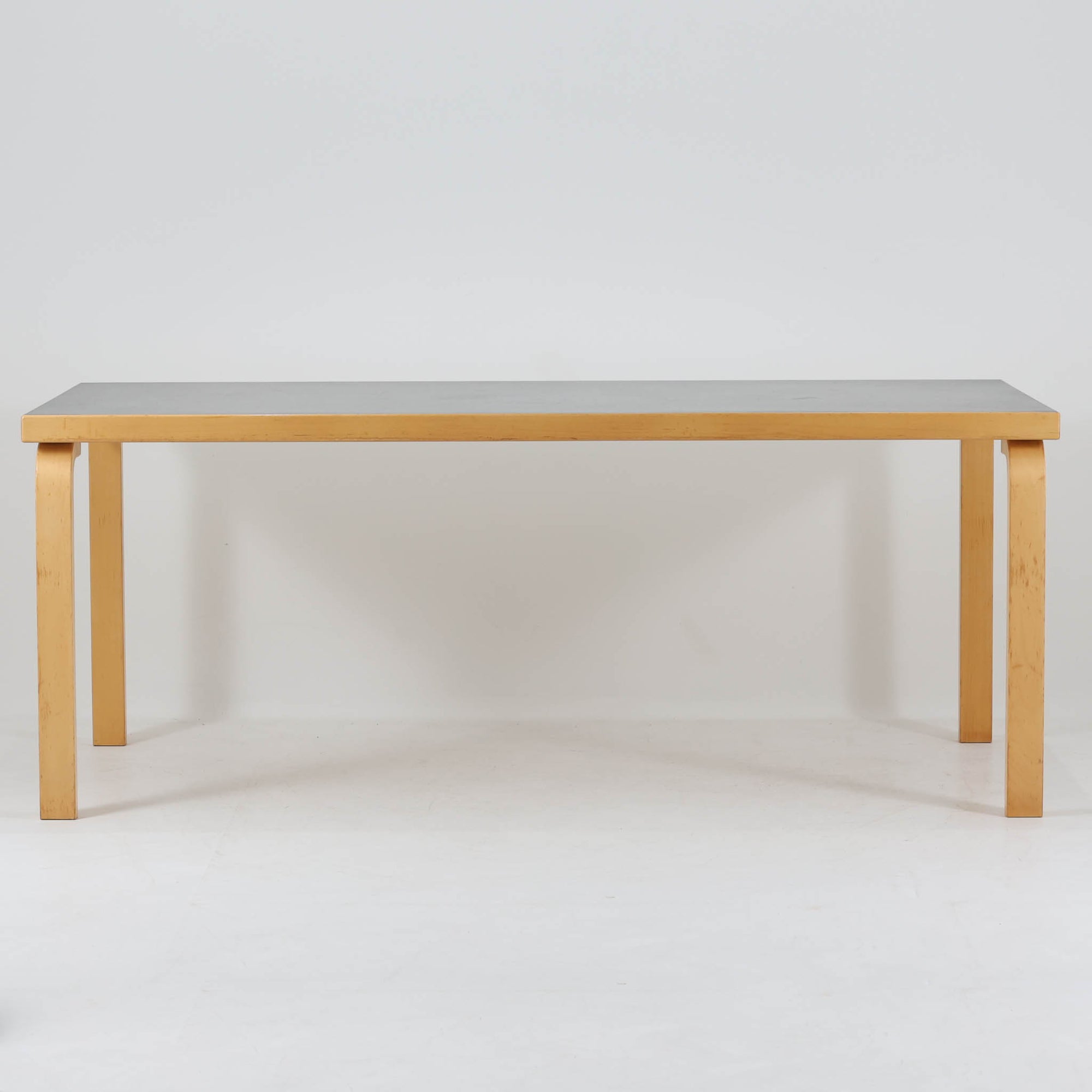 Alvar Aaltoが手掛けたArtekの名作「Table 83」です。バーチ材のフレームにリノリウム天板を組み合わせた、機能美あふれるデザインが魅力。アアルトを象徴するLレッグ構造は、無駄を削ぎ落とした軽やかなフォルムと優れた耐久性を両立しています。幅182cmのゆとりあるサイズはダイニングテーブルとしてはもちろん、ワークテーブルやミーティングテーブルとしても活躍。長年愛され続ける北欧モダンデザインとビンテージならではの風合いを楽しめる一台です。