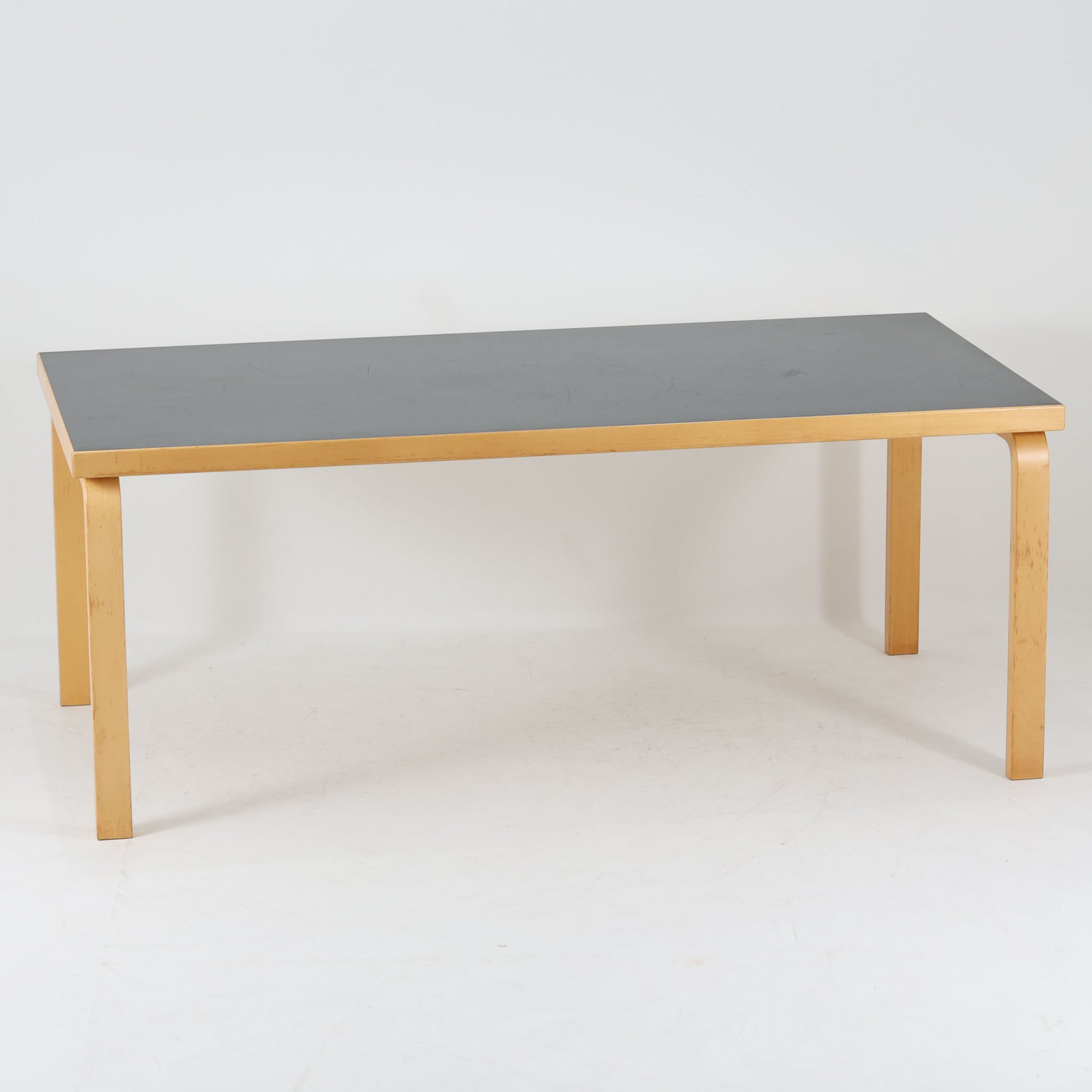 Alvar Aaltoが手掛けたArtekの名作「Table 83」です。バーチ材のフレームにリノリウム天板を組み合わせた、機能美あふれるデザインが魅力。アアルトを象徴するLレッグ構造は、無駄を削ぎ落とした軽やかなフォルムと優れた耐久性を両立しています。幅182cmのゆとりあるサイズはダイニングテーブルとしてはもちろん、ワークテーブルやミーティングテーブルとしても活躍。長年愛され続ける北欧モダンデザインとビンテージならではの風合いを楽しめる一台です。