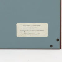 Adam Hoff & Poul Ostergaardがデザインし、Virum Mobelsnickeriにより製作された「The Hanger」ハンガーラックです。チーク材の温かみある木目と、優雅な曲線を描くベースのフォルムが印象的なデザイン。内部にはフックが備えられ、コートや帽子などを掛けて収納できます。フロントのフラップを開くとハンガー部分が現れる機能的な構造で、使用しないときはすっきりとした壁面収納として美しく収まります。革ベルトによる固定や細部の造りにも職人技が感じられる、北欧ビンテージならではの洗練された一品です。