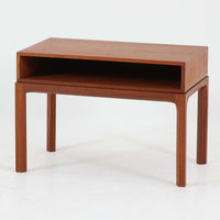 Kai Kristiansenがデザインし、Aksel Kjersgaardが手掛けたNo.383 サイドテーブルです。チーク材の美しい木目と経年により深みを増した色合いが魅力で、天板下に設けられたオープンスペースが軽やかな印象と実用性を兼ね備えています。脚部は内側に滑らかな曲線で接合されており、シンプルながらも洗練された構造美が際立つ一台。ソファサイドやベッドサイドでの使用はもちろん、雑誌や小物をすっきりと収める収納としても活躍します。北欧ビンテージならではの丁寧な木工技術と希少性を感じられる逸品です。