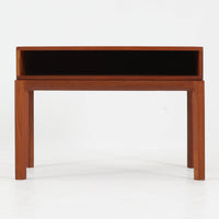 Kai Kristiansenがデザインし、Aksel Kjersgaardが手掛けたNo.383 サイドテーブルです。チーク材の美しい木目と経年により深みを増した色合いが魅力で、天板下に設けられたオープンスペースが軽やかな印象と実用性を兼ね備えています。脚部は内側に滑らかな曲線で接合されており、シンプルながらも洗練された構造美が際立つ一台。ソファサイドやベッドサイドでの使用はもちろん、雑誌や小物をすっきりと収める収納としても活躍します。北欧ビンテージならではの丁寧な木工技術と希少性を感じられる逸品です。