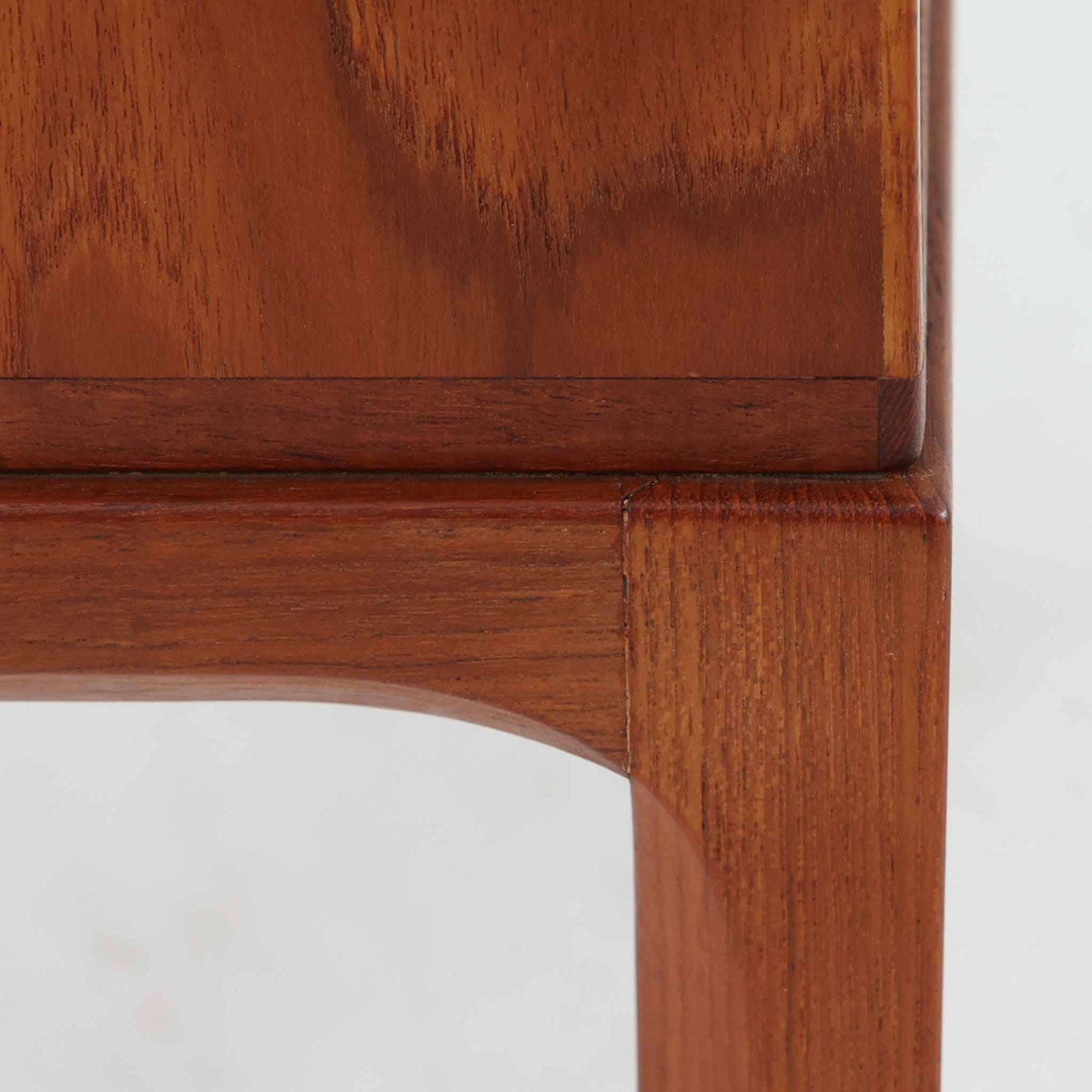 Kai Kristiansenがデザインし、Aksel Kjersgaardが手掛けたNo.383 サイドテーブルです。チーク材の美しい木目と経年により深みを増した色合いが魅力で、天板下に設けられたオープンスペースが軽やかな印象と実用性を兼ね備えています。脚部は内側に滑らかな曲線で接合されており、シンプルながらも洗練された構造美が際立つ一台。ソファサイドやベッドサイドでの使用はもちろん、雑誌や小物をすっきりと収める収納としても活躍します。北欧ビンテージならではの丁寧な木工技術と希少性を感じられる逸品です。