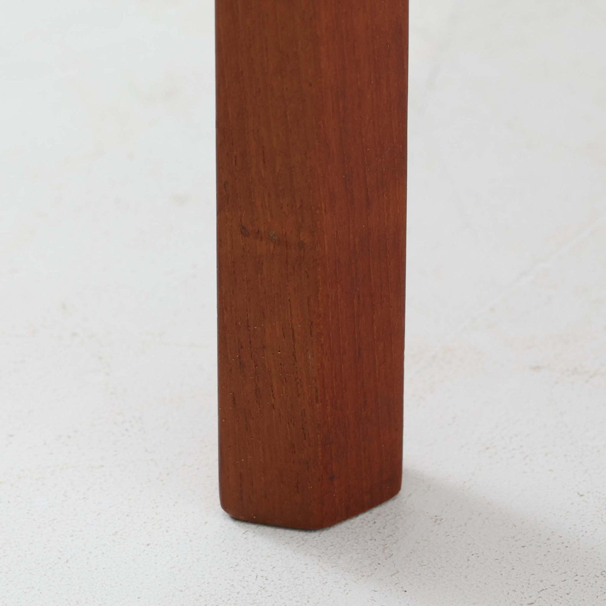 Kai Kristiansenがデザインし、Aksel Kjersgaardが手掛けたNo.383 サイドテーブルです。チーク材の美しい木目と経年により深みを増した色合いが魅力で、天板下に設けられたオープンスペースが軽やかな印象と実用性を兼ね備えています。脚部は内側に滑らかな曲線で接合されており、シンプルながらも洗練された構造美が際立つ一台。ソファサイドやベッドサイドでの使用はもちろん、雑誌や小物をすっきりと収める収納としても活躍します。北欧ビンテージならではの丁寧な木工技術と希少性を感じられる逸品です。