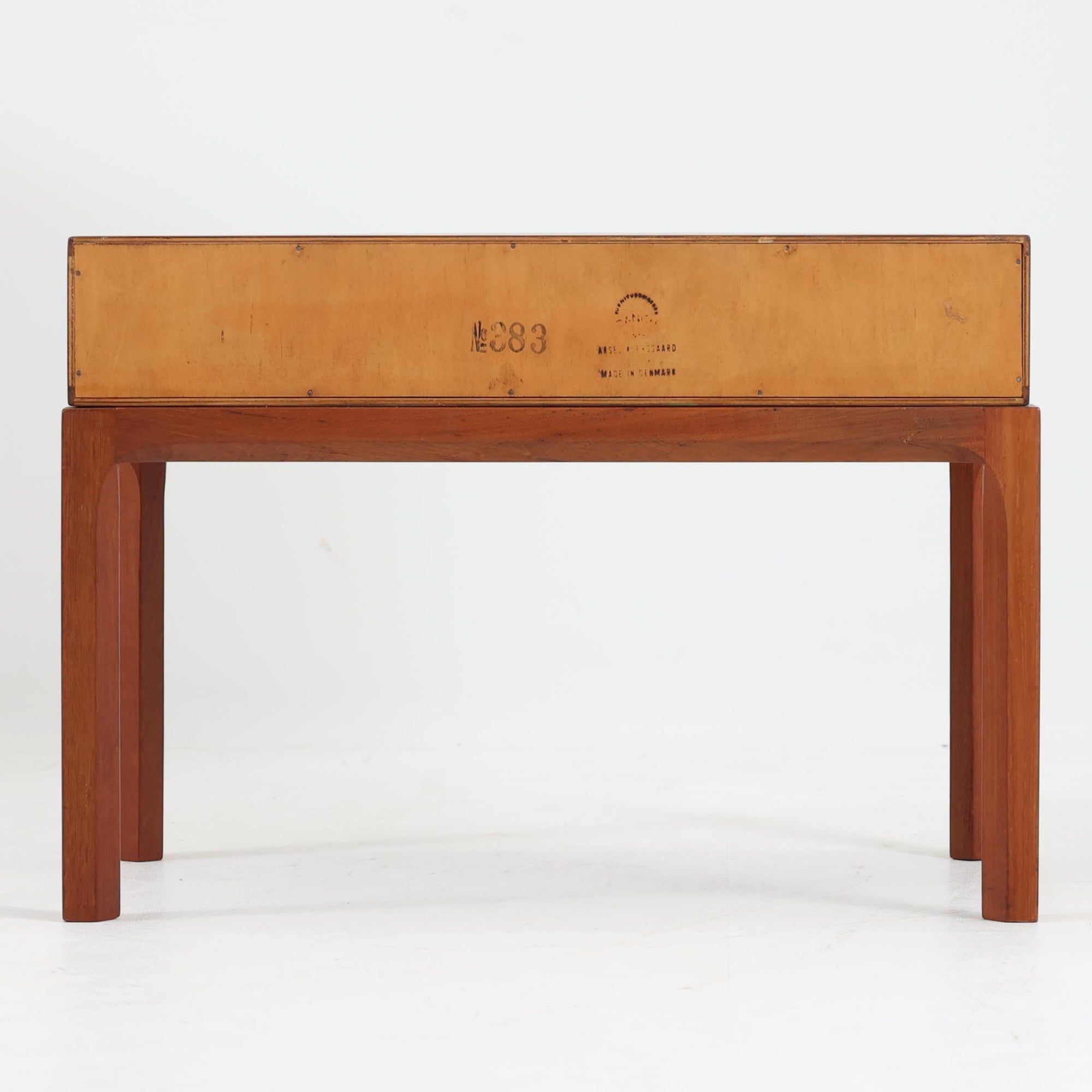 Kai Kristiansenがデザインし、Aksel Kjersgaardが手掛けたNo.383 サイドテーブルです。チーク材の美しい木目と経年により深みを増した色合いが魅力で、天板下に設けられたオープンスペースが軽やかな印象と実用性を兼ね備えています。脚部は内側に滑らかな曲線で接合されており、シンプルながらも洗練された構造美が際立つ一台。ソファサイドやベッドサイドでの使用はもちろん、雑誌や小物をすっきりと収める収納としても活躍します。北欧ビンテージならではの丁寧な木工技術と希少性を感じられる逸品です。