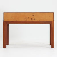 Kai Kristiansenがデザインし、Aksel Kjersgaardが手掛けたNo.383 サイドテーブルです。チーク材の美しい木目と経年により深みを増した色合いが魅力で、天板下に設けられたオープンスペースが軽やかな印象と実用性を兼ね備えています。脚部は内側に滑らかな曲線で接合されており、シンプルながらも洗練された構造美が際立つ一台。ソファサイドやベッドサイドでの使用はもちろん、雑誌や小物をすっきりと収める収納としても活躍します。北欧ビンテージならではの丁寧な木工技術と希少性を感じられる逸品です。