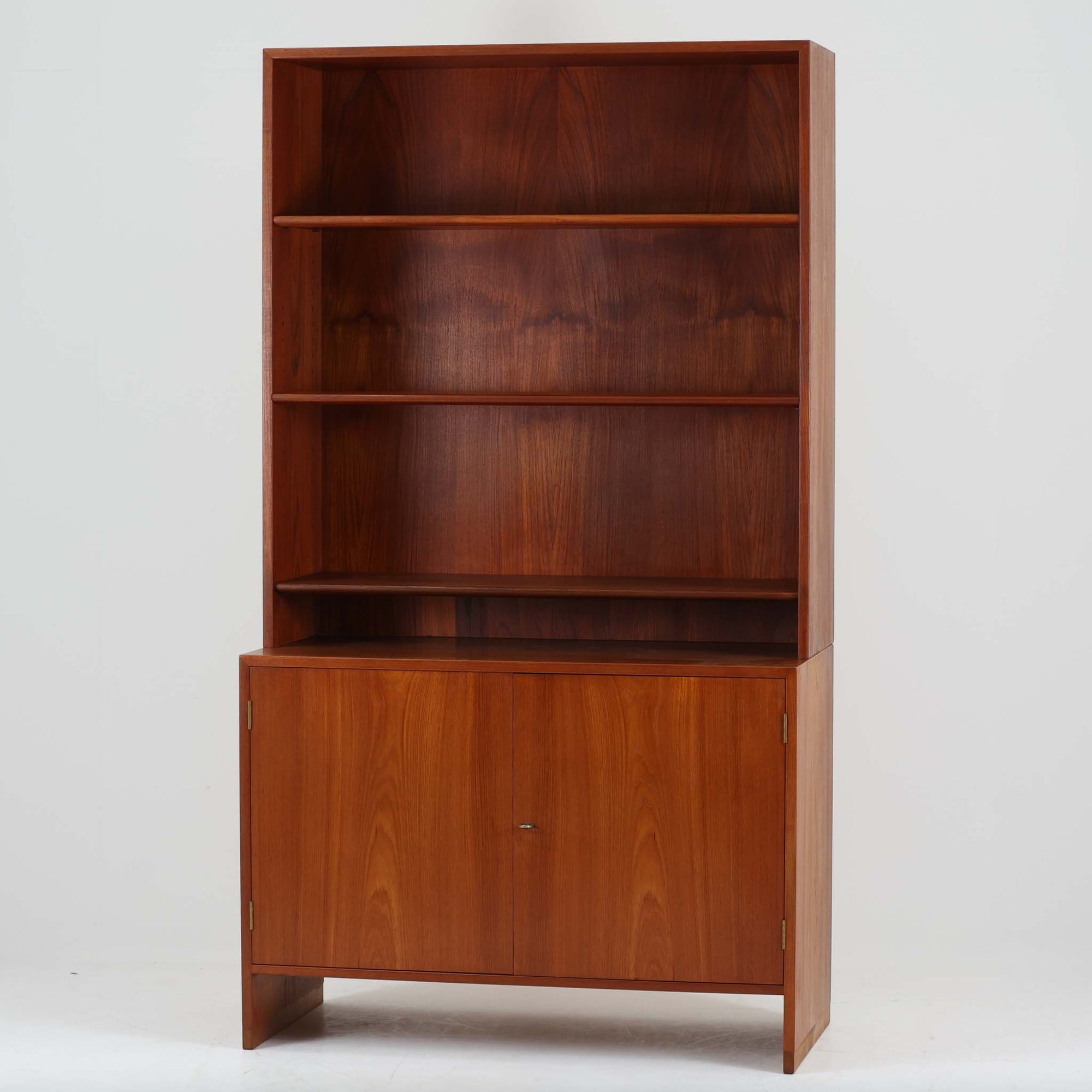 Hans J. Wegnerがデザインし、Ry Moblerが製作したディスプレイシェルフです。美しい木目をもつチーク材を主体に、内部や構造部にはオーク材、金具には真鍮を組み合わせた上質なつくりが魅力。上部のオープン棚は飾り棚として器やオブジェ、本を美しく見せ、下部の開き戸収納は細かい日用品や書類をすっきり隠して収納できます。直線的で端正なフォルムの中に、ウェグナーらしい丁寧な木工技術と素材の美しさが息づき、経年で深みを増した色艶が空間に格別の存在感を添える一品です。リビングや書斎、ショップ什器としてもおすすめです。