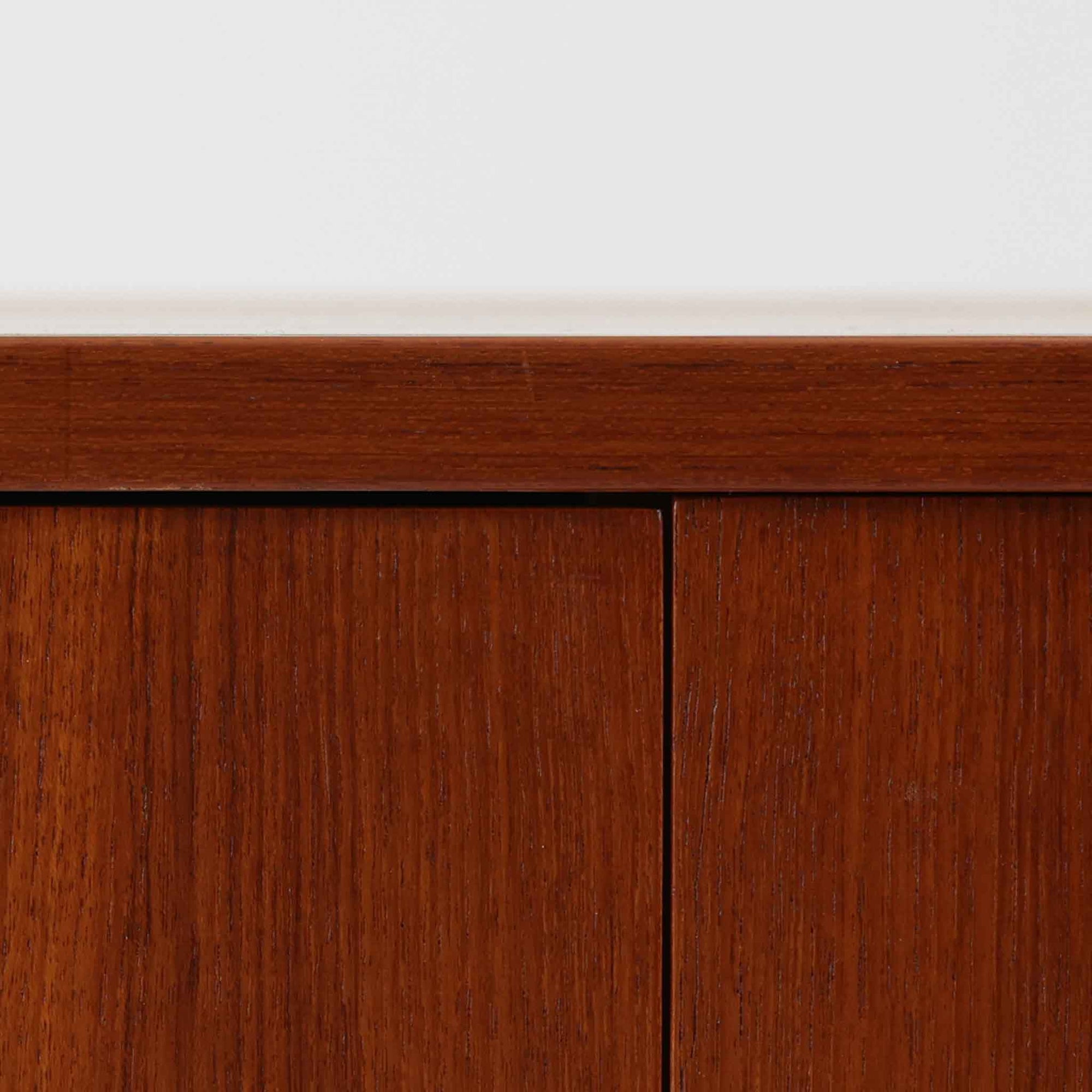 Hans J. Wegnerがデザインし、Ry Moblerが製作したディスプレイシェルフです。美しい木目をもつチーク材を主体に、内部や構造部にはオーク材、金具には真鍮を組み合わせた上質なつくりが魅力。上部のオープン棚は飾り棚として器やオブジェ、本を美しく見せ、下部の開き戸収納は細かい日用品や書類をすっきり隠して収納できます。直線的で端正なフォルムの中に、ウェグナーらしい丁寧な木工技術と素材の美しさが息づき、経年で深みを増した色艶が空間に格別の存在感を添える一品です。リビングや書斎、ショップ什器としてもおすすめです。