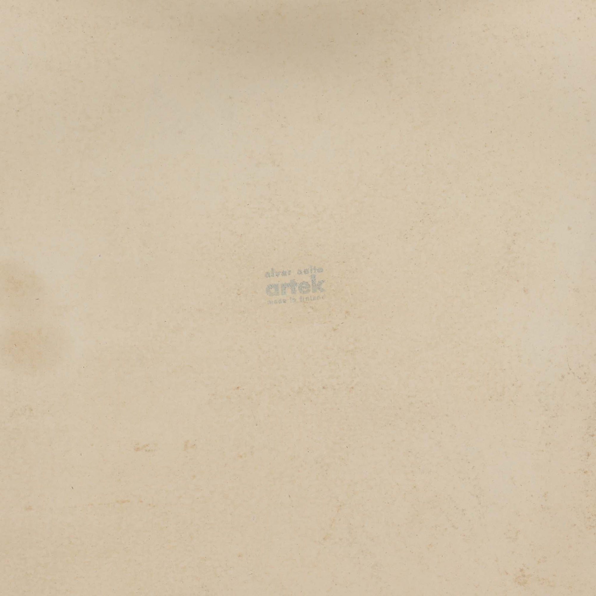 Alvar Aaltoがデザインし、Artekより製作された「81C」ダイニングテーブルです。バーチ材を用いたフレームに、天板には落ち着いた質感のリノリウムを組み合わせたシンプルで機能的なデザインが特徴。脚部にはアアルトを象徴するL字型の曲木構造が採用されており、軽やかで柔らかな印象を与えます。幅75cmの正方形サイズはダイニングはもちろんワークテーブルとしても使いやすく、日常の空間に北欧デザインの美しさと実用性をもたらすビンテージ家具です。本個体は、脚部の5枚レイヤー構造、1973年以降に採用されたプラスネジ、および天板裏の3段構成スタンプの仕様から、1973年～1990年代始めに掛けて製造されたと思われます。