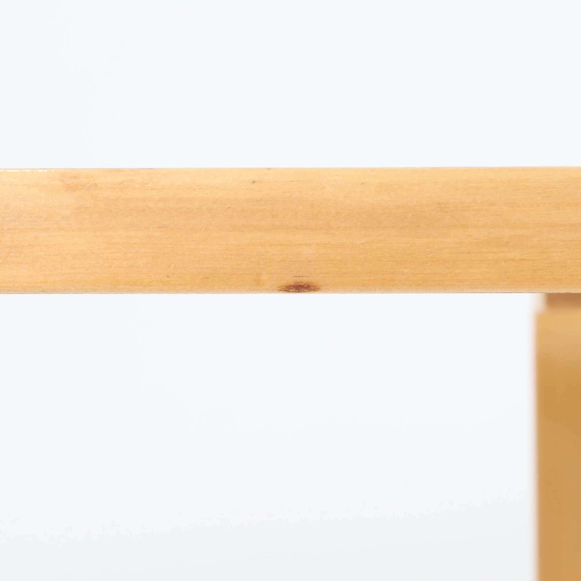 Alvar Aaltoがデザインし、Artekより製作された「81C」ダイニングテーブルです。バーチ材を用いたフレームに、天板には落ち着いた質感のリノリウムを組み合わせたシンプルで機能的なデザインが特徴。脚部にはアアルトを象徴するL字型の曲木構造が採用されており、軽やかで柔らかな印象を与えます。幅75cmの正方形サイズはダイニングはもちろんワークテーブルとしても使いやすく、日常の空間に北欧デザインの美しさと実用性をもたらすビンテージ家具です。本個体は、脚部の5枚レイヤー構造、1973年以降に採用されたプラスネジ、および天板裏の3段構成スタンプの仕様から、1973年～1990年代始めに掛けて製造されたと思われます。