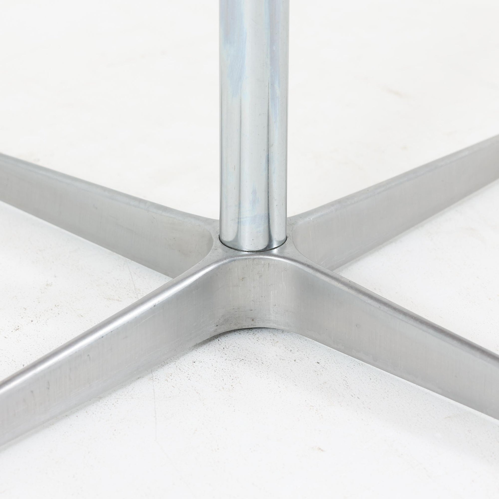 Arne Jacobsenがデザインし、Fritz Hansenが製作した円形ダイニングテーブルです。直径90cmのチーク無垢天板は、豊かな木目と滑らかな円形フォルムが美しく、空間に柔らかな印象をもたらします。シャープなスチール製の一本脚と4本スポークベースが軽快で洗練された佇まいを生み、ヤコブセンらしい機能美が際立つ一台。2～4人で使いやすいサイズ感で、ダイニングテーブルとしてはもちろん、カフェテーブルやラウンジ空間での打ち合わせ用テーブルとしてもおすすめです。中でもチーク無垢材仕様の個体は流通数が少なく珍しく、北欧ビンテージ市場でも希少性の高いモデルとして魅力を放ちます。経年により深みを増した木肌と無駄のない構造が、空間に上質な存在感を添えてくれます。