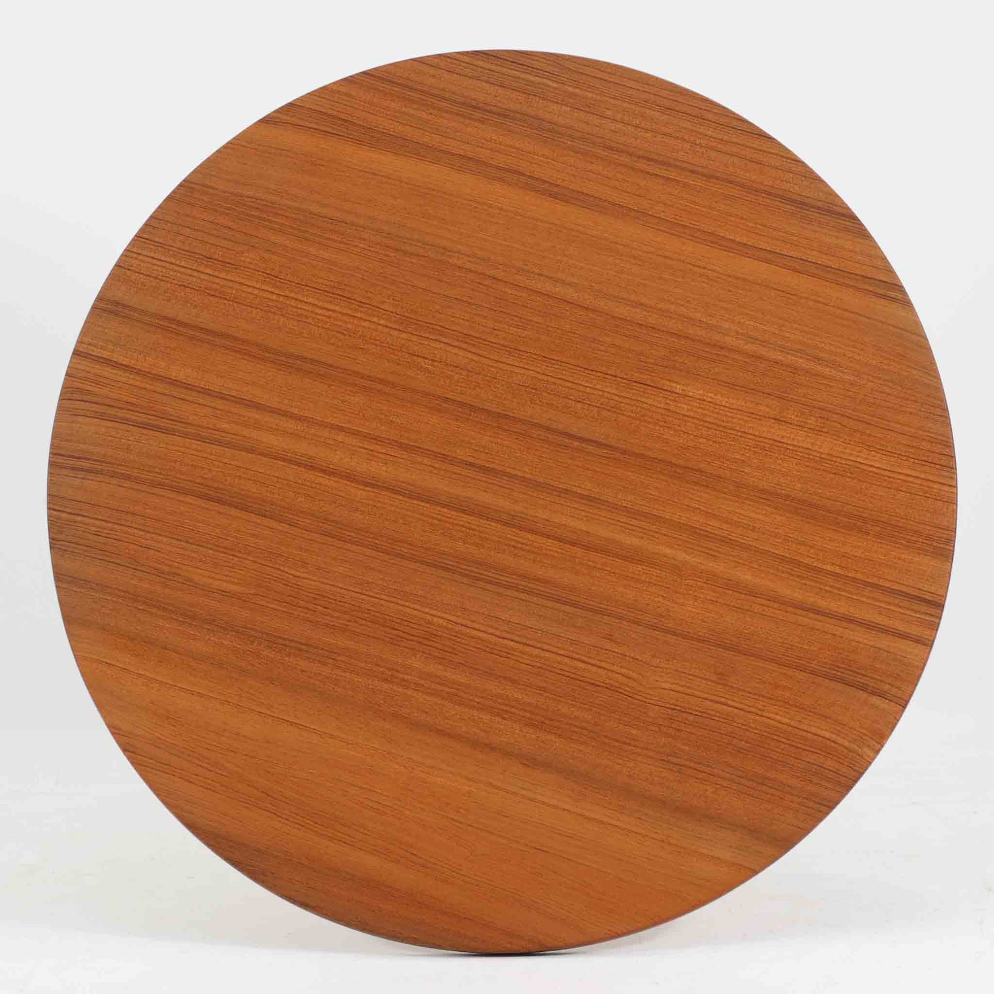 Arne Jacobsenがデザインし、Fritz Hansenが製作した円形ダイニングテーブルです。直径90cmのチーク無垢天板は、豊かな木目と滑らかな円形フォルムが美しく、空間に柔らかな印象をもたらします。シャープなスチール製の一本脚と4本スポークベースが軽快で洗練された佇まいを生み、ヤコブセンらしい機能美が際立つ一台。2～4人で使いやすいサイズ感で、ダイニングテーブルとしてはもちろん、カフェテーブルやラウンジ空間での打ち合わせ用テーブルとしてもおすすめです。中でもチーク無垢材仕様の個体は流通数が少なく珍しく、北欧ビンテージ市場でも希少性の高いモデルとして魅力を放ちます。経年により深みを増した木肌と無駄のない構造が、空間に上質な存在感を添えてくれます。