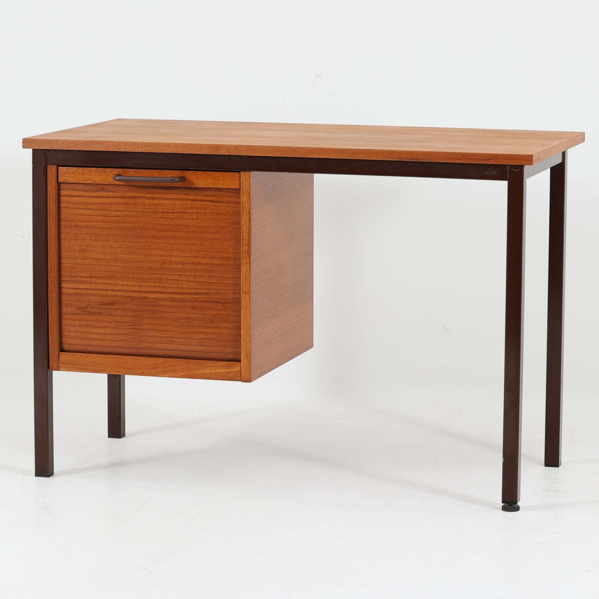 Labofa（ラボファ）によるデンマーク製の片袖デスクです。幅100cmの扱いやすいサイズに、蛇腹扉を備えた片袖収納とシャープなスチール脚を組み合わせた、機能美あふれる北欧デザインが魅力の一台。収納内部には複数のスライドトレイが備えられ、書類や文具、小物を効率よく整理できる実用的な構造です。チーク材ならではの美しい木目と経年で深みを増した艶やかな木肌が、ワークスペースに上質な温もりを添えます。限られた空間にも取り入れやすく、ホームオフィスや書斎、ショップのレジデスクとしても活躍。ビンテージならではの丁寧な造りと希少な蛇腹機構が、空間に洗練された存在感をもたらします。