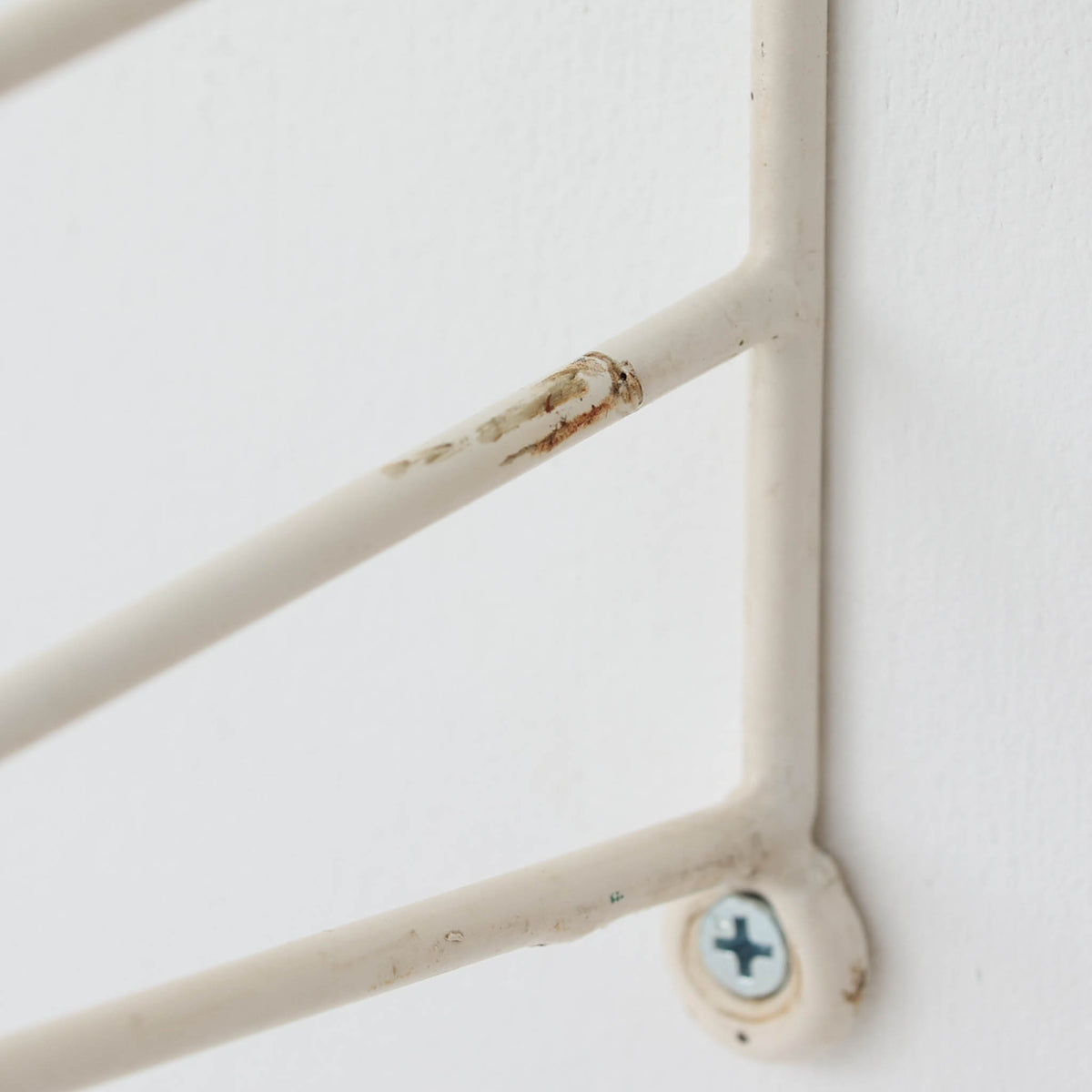 Nils Strinningがデザインし、String Design ABが製造したチーク材のウォールシェルフです。細身の金属製サイドフレームに3枚の木製棚板を組み合わせた軽快な構成で、圧迫感を抑えながら書籍や器、オブジェなどを美しく飾ることができます。棚板の位置を調整しやすい機能的な構造と、直線的で無駄のない造形は北欧らしい合理性を感じさせ、チーク材の経年による深い色合いと金属フレームの対比も魅力。リビングや書斎、店舗空間の壁面を有効に使える存在感ある一台です。