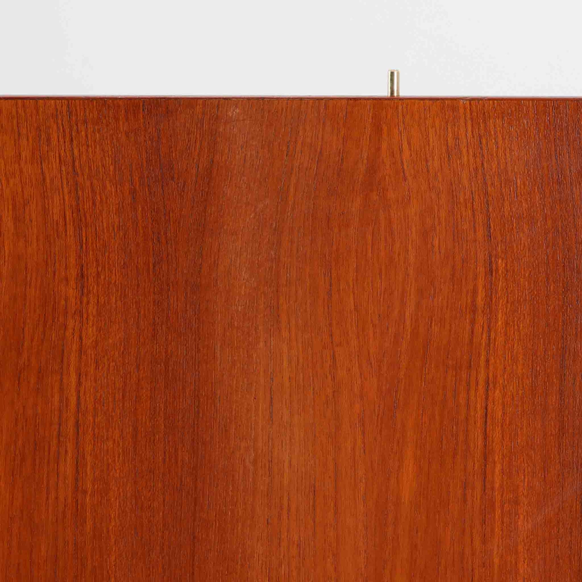 B. Fridhagenがデザインし、Bodaforsが製作したディスプレイシェルフです。チーク材ならではの美しい木目と経年で深みを増した艶やかな色合いが魅力で、上部のオープン棚と下部の引き戸収納を組み合わせた実用性の高い構成が北欧らしい機能美を感じさせます。幅90cmのすっきりとしたサイズは、書籍やオブジェ、器のディスプレイはもちろん、リビングや書斎での見せる収納と隠す収納を両立。細身の脚部が軽やかな印象を添え、Bodaforsらしい丁寧な木工技術とビンテージならではの希少性が空間に上質な存在感をもたらします。