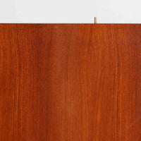 B. Fridhagenがデザインし、Bodaforsが製作したディスプレイシェルフです。チーク材ならではの美しい木目と経年で深みを増した艶やかな色合いが魅力で、上部のオープン棚と下部の引き戸収納を組み合わせた実用性の高い構成が北欧らしい機能美を感じさせます。幅90cmのすっきりとしたサイズは、書籍やオブジェ、器のディスプレイはもちろん、リビングや書斎での見せる収納と隠す収納を両立。細身の脚部が軽やかな印象を添え、Bodaforsらしい丁寧な木工技術とビンテージならではの希少性が空間に上質な存在感をもたらします。