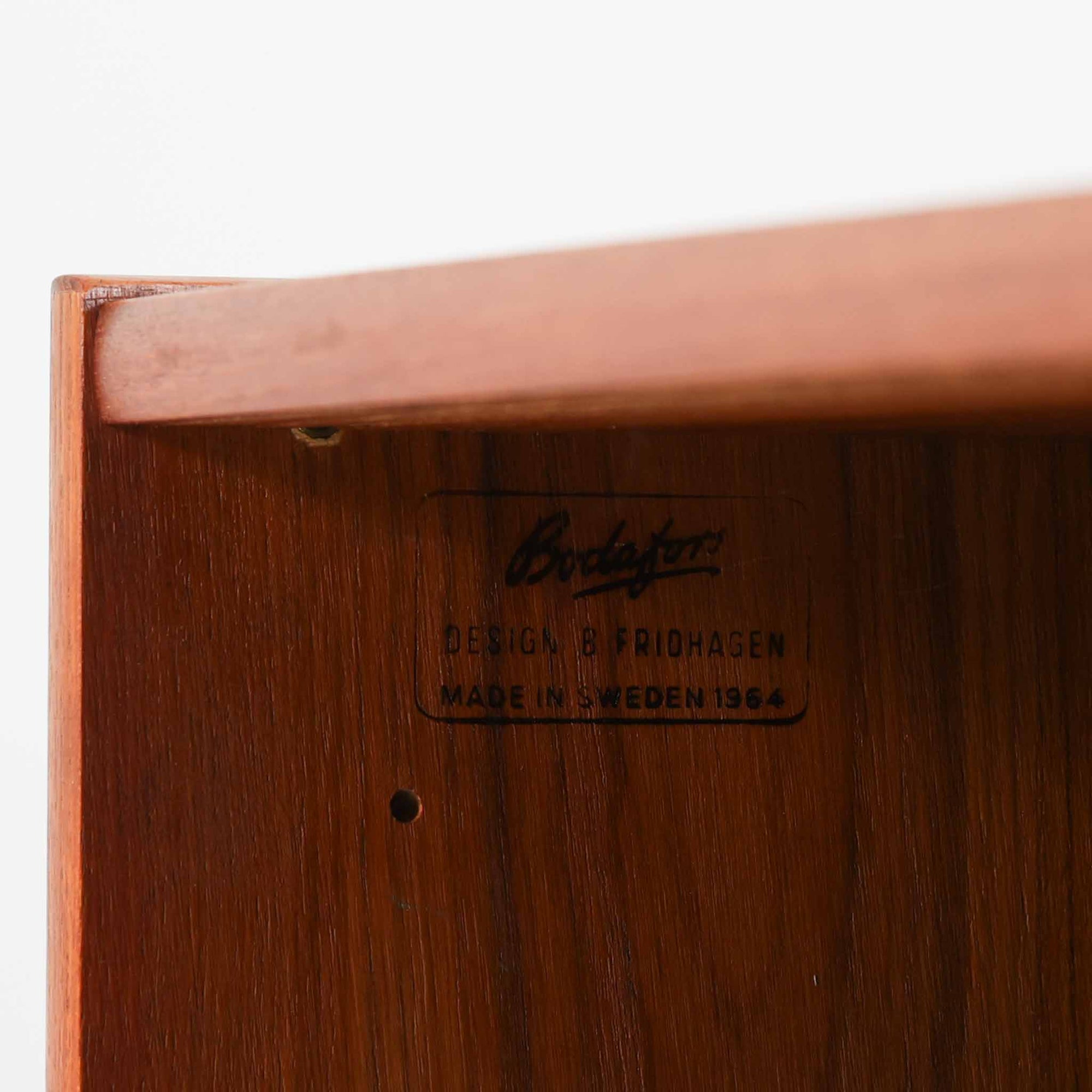 B. Fridhagenがデザインし、Bodaforsが製作したディスプレイシェルフです。チーク材ならではの美しい木目と経年で深みを増した艶やかな色合いが魅力で、上部のオープン棚と下部の引き戸収納を組み合わせた実用性の高い構成が北欧らしい機能美を感じさせます。幅90cmのすっきりとしたサイズは、書籍やオブジェ、器のディスプレイはもちろん、リビングや書斎での見せる収納と隠す収納を両立。細身の脚部が軽やかな印象を添え、Bodaforsらしい丁寧な木工技術とビンテージならではの希少性が空間に上質な存在感をもたらします。