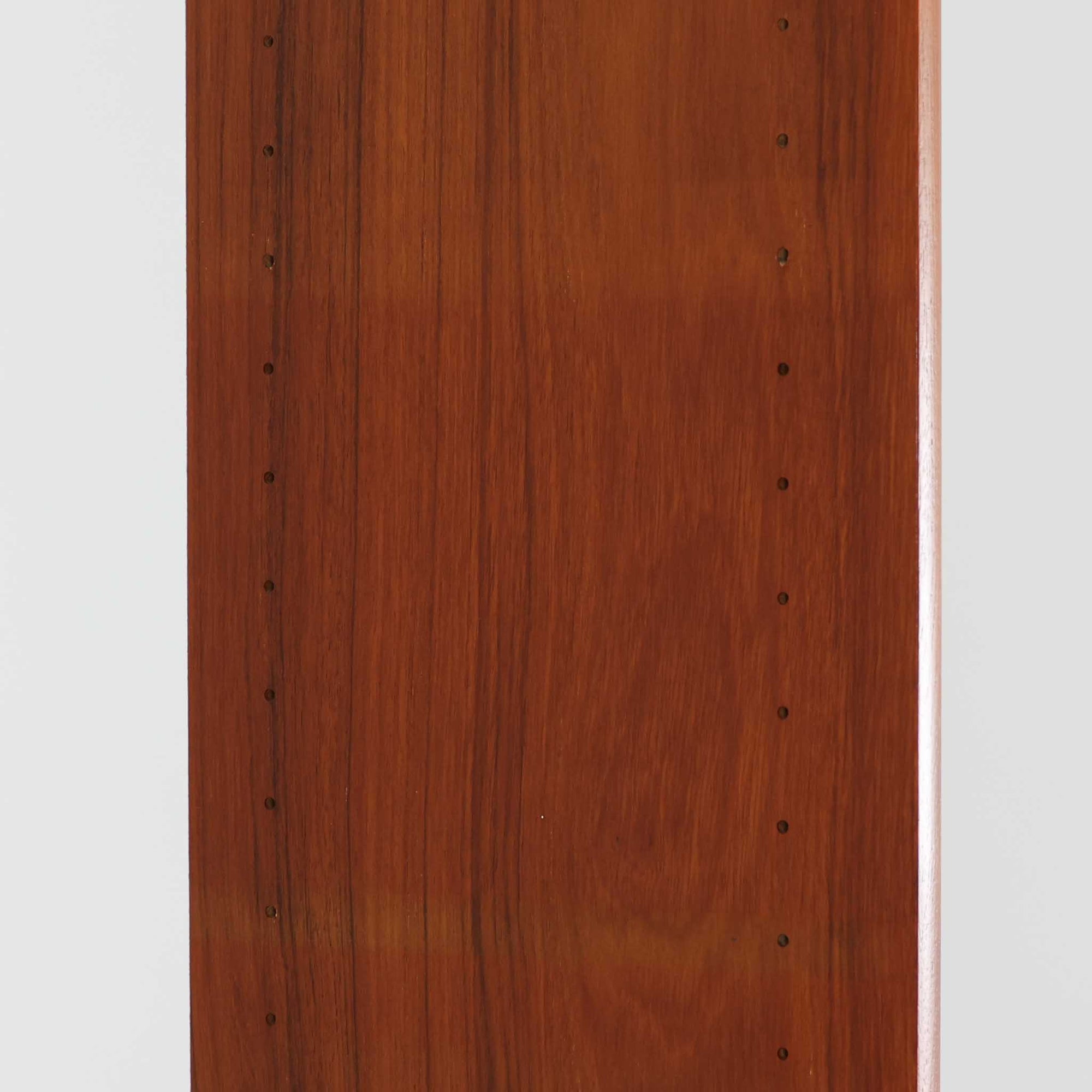 B. Fridhagenがデザインし、Bodaforsが製作したディスプレイシェルフです。チーク材ならではの美しい木目と経年で深みを増した艶やかな色合いが魅力で、上部のオープン棚と下部の引き戸収納を組み合わせた実用性の高い構成が北欧らしい機能美を感じさせます。幅90cmのすっきりとしたサイズは、書籍やオブジェ、器のディスプレイはもちろん、リビングや書斎での見せる収納と隠す収納を両立。細身の脚部が軽やかな印象を添え、Bodaforsらしい丁寧な木工技術とビンテージならではの希少性が空間に上質な存在感をもたらします。