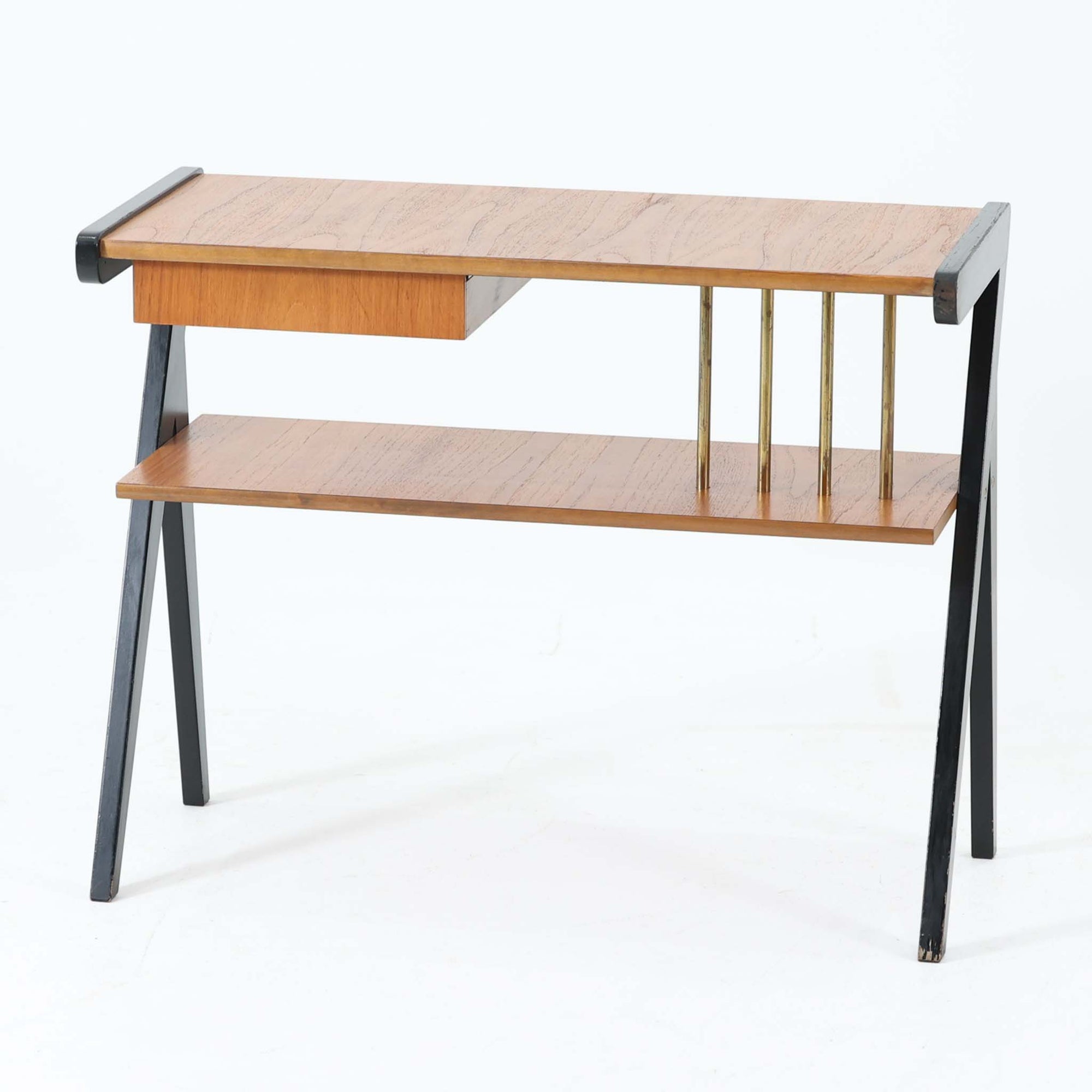 チーク材の天板とビーチ材の棚板、メタル支柱を組み合わせた異素材ミックスの構造が印象的で、ブラック塗装のフレームが全体を引き締めた軽快なデザインに仕上がっています。引き出し付きで小物収納に便利なほか、雑誌やレコードを立て掛けられる機能的な仕切りも備え、リビングや玄関先など多用途に活躍。北欧ビンテージらしい実用性と個性を兼ね備えた一台です。