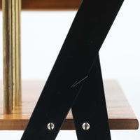 チーク材の天板とビーチ材の棚板、メタル支柱を組み合わせた異素材ミックスの構造が印象的で、ブラック塗装のフレームが全体を引き締めた軽快なデザインに仕上がっています。引き出し付きで小物収納に便利なほか、雑誌やレコードを立て掛けられる機能的な仕切りも備え、リビングや玄関先など多用途に活躍。北欧ビンテージらしい実用性と個性を兼ね備えた一台です。