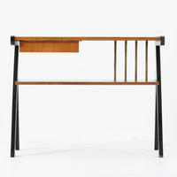 チーク材の天板とビーチ材の棚板、メタル支柱を組み合わせた異素材ミックスの構造が印象的で、ブラック塗装のフレームが全体を引き締めた軽快なデザインに仕上がっています。引き出し付きで小物収納に便利なほか、雑誌やレコードを立て掛けられる機能的な仕切りも備え、リビングや玄関先など多用途に活躍。北欧ビンテージらしい実用性と個性を兼ね備えた一台です。